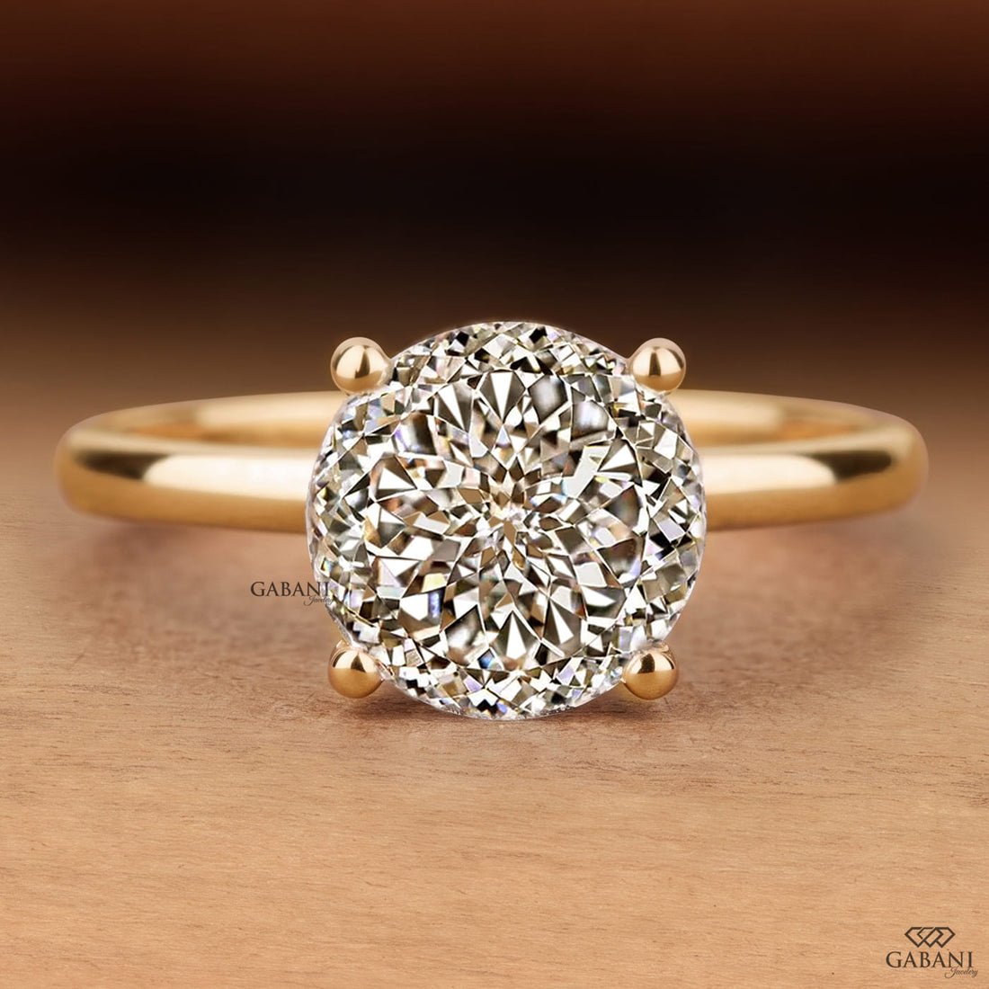 Round cut lab grown diamond solitaire engagement ring with four-prong setting and polished yellow gold band.