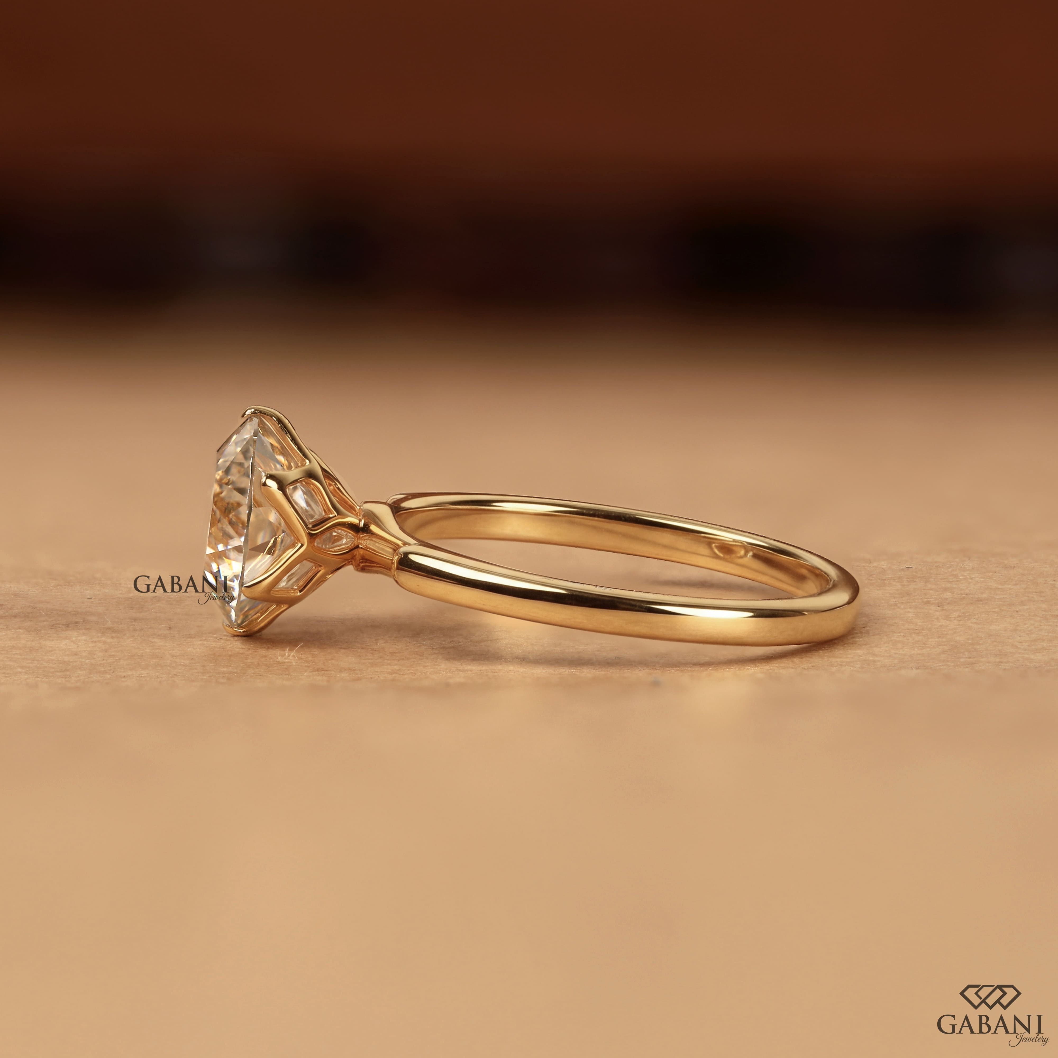 Round Portuguese cut lab grown diamond solitaire engagement ring in yellow gold with a six-prong tulip basket and polished plain band.