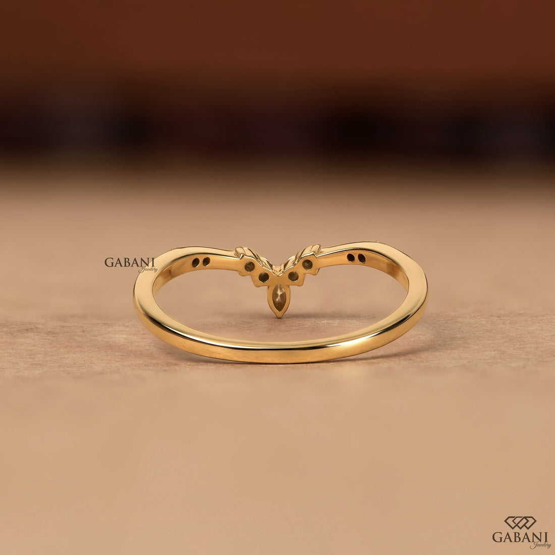 Marquise and round cut lab grown diamond curved wedding band in yellow gold with V shaped contour design for stacking with an engagement ring.