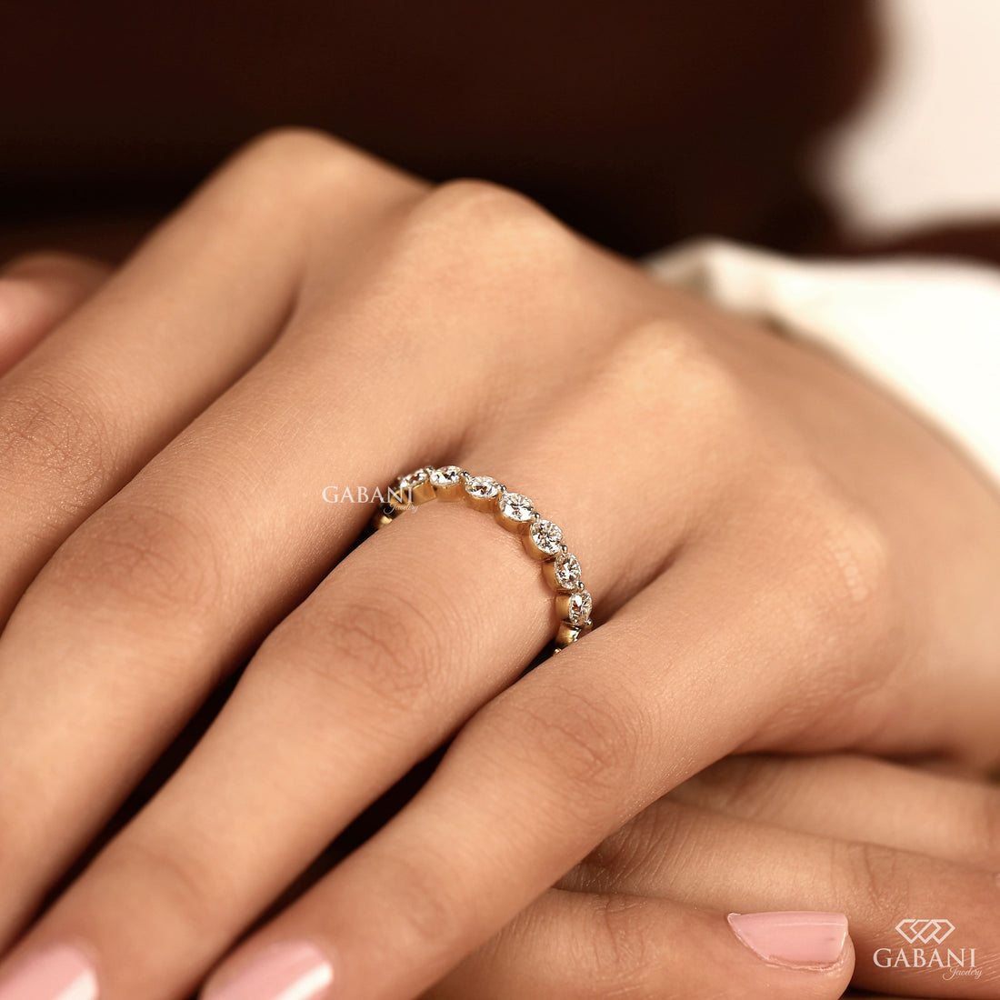 Round cut lab grown diamond full eternity wedding band in yellow gold with shared prong setting.