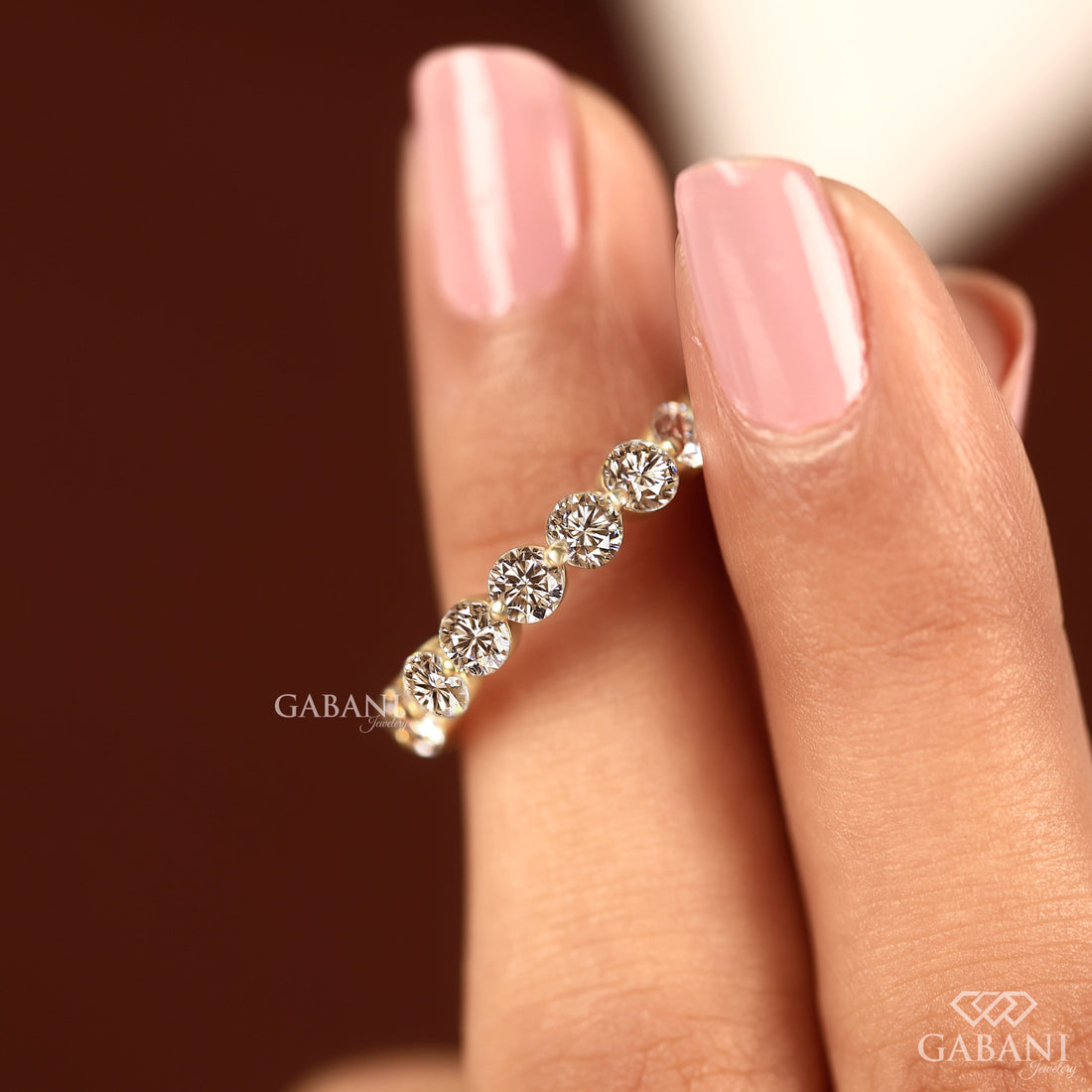Round lab grown diamond shared prong full eternity wedding band in yellow gold with continuous diamond setting.