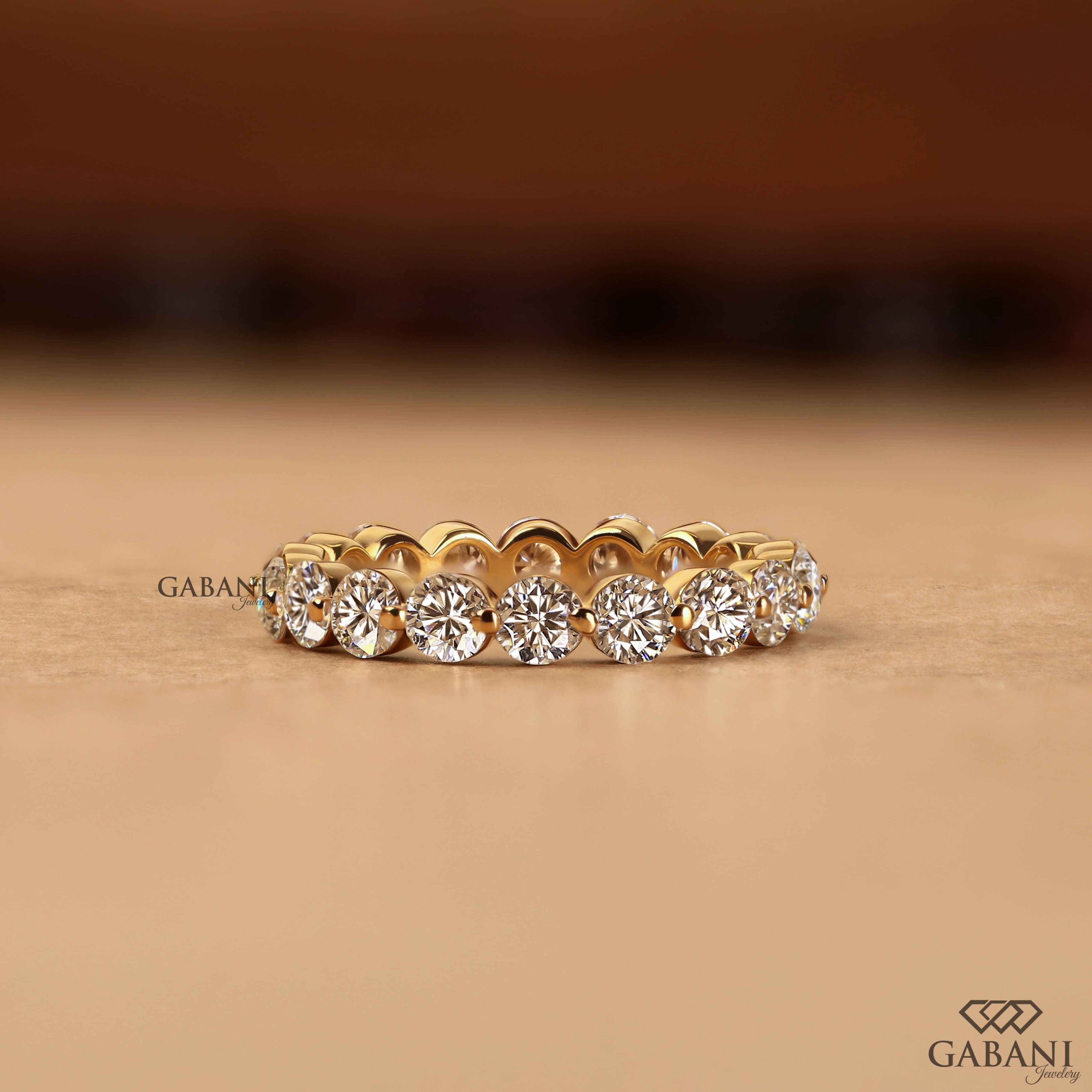 Round lab grown diamond shared prong full eternity wedding band in yellow gold with continuous diamond setting.