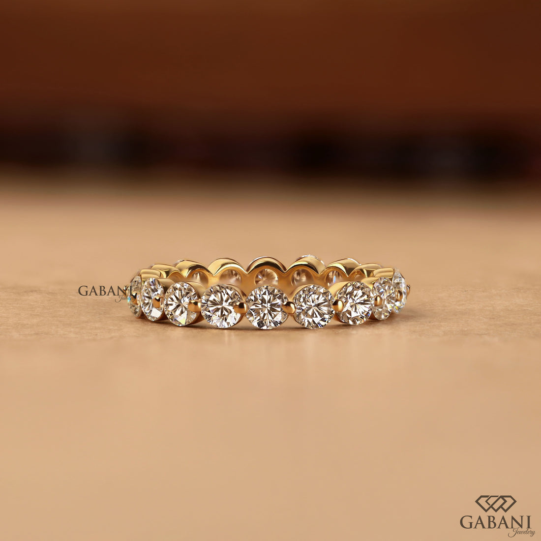 Round lab grown diamond shared prong full eternity wedding band in yellow gold with continuous diamond setting.
