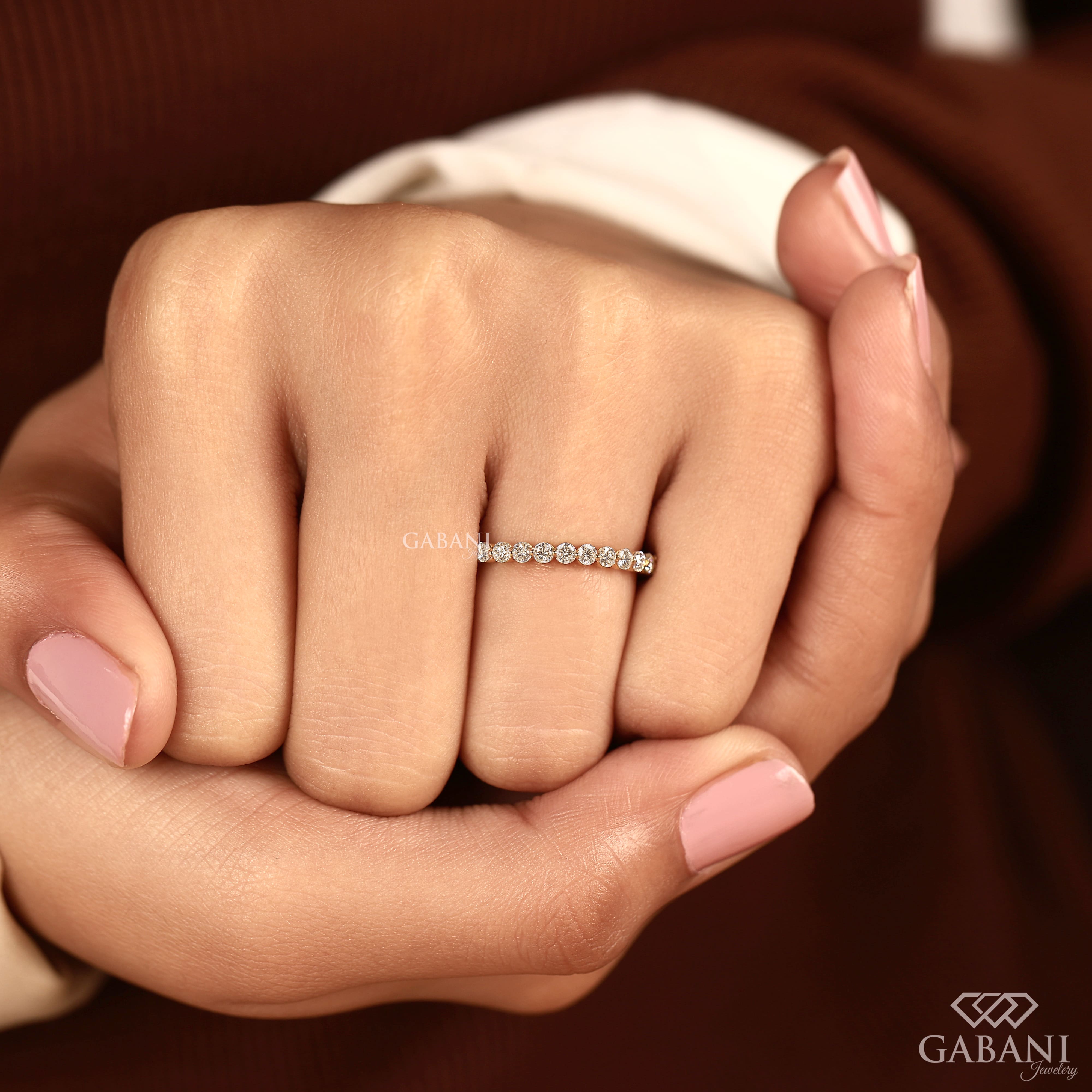 Round cut lab grown diamond full eternity wedding band in yellow gold with shared prong setting and continuous diamond design.