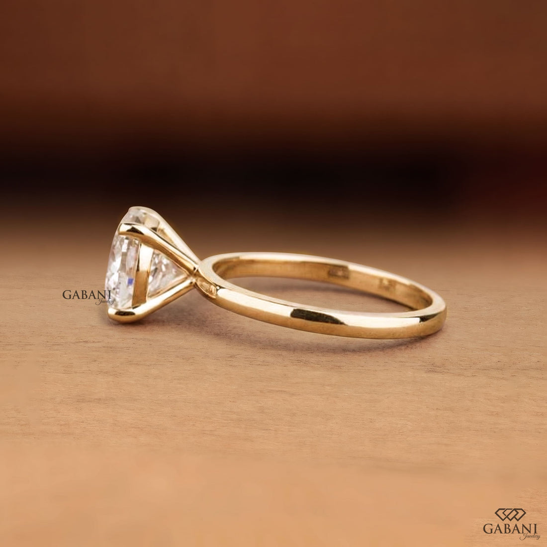 Round cut lab grown diamond solitaire engagement ring with four-prong setting and polished yellow gold band.