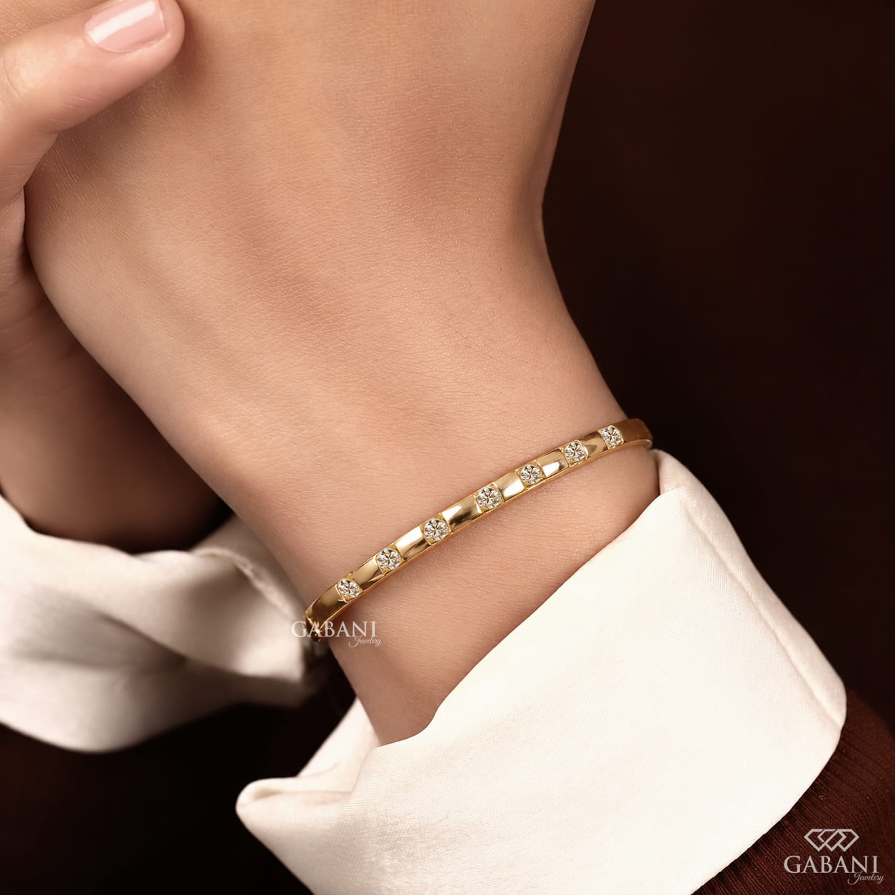 a round lab grown diamond bangle bracelet in yellow gold, featuring evenly spaced sparkling diamonds between polished gold bars in a modern geometric design by Gabani Jewelry.