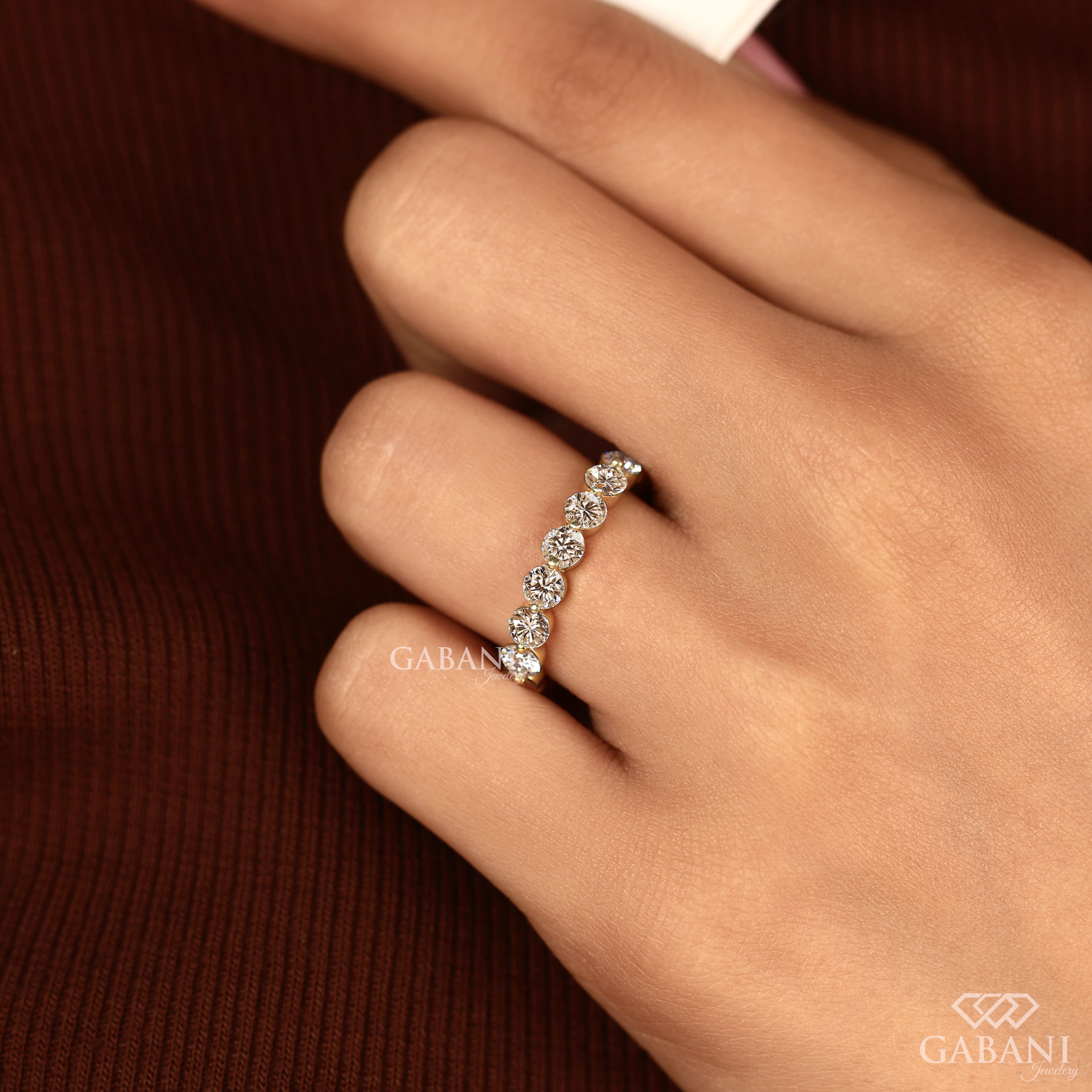 Round lab grown diamond shared prong full eternity wedding band in yellow gold with continuous diamond setting.