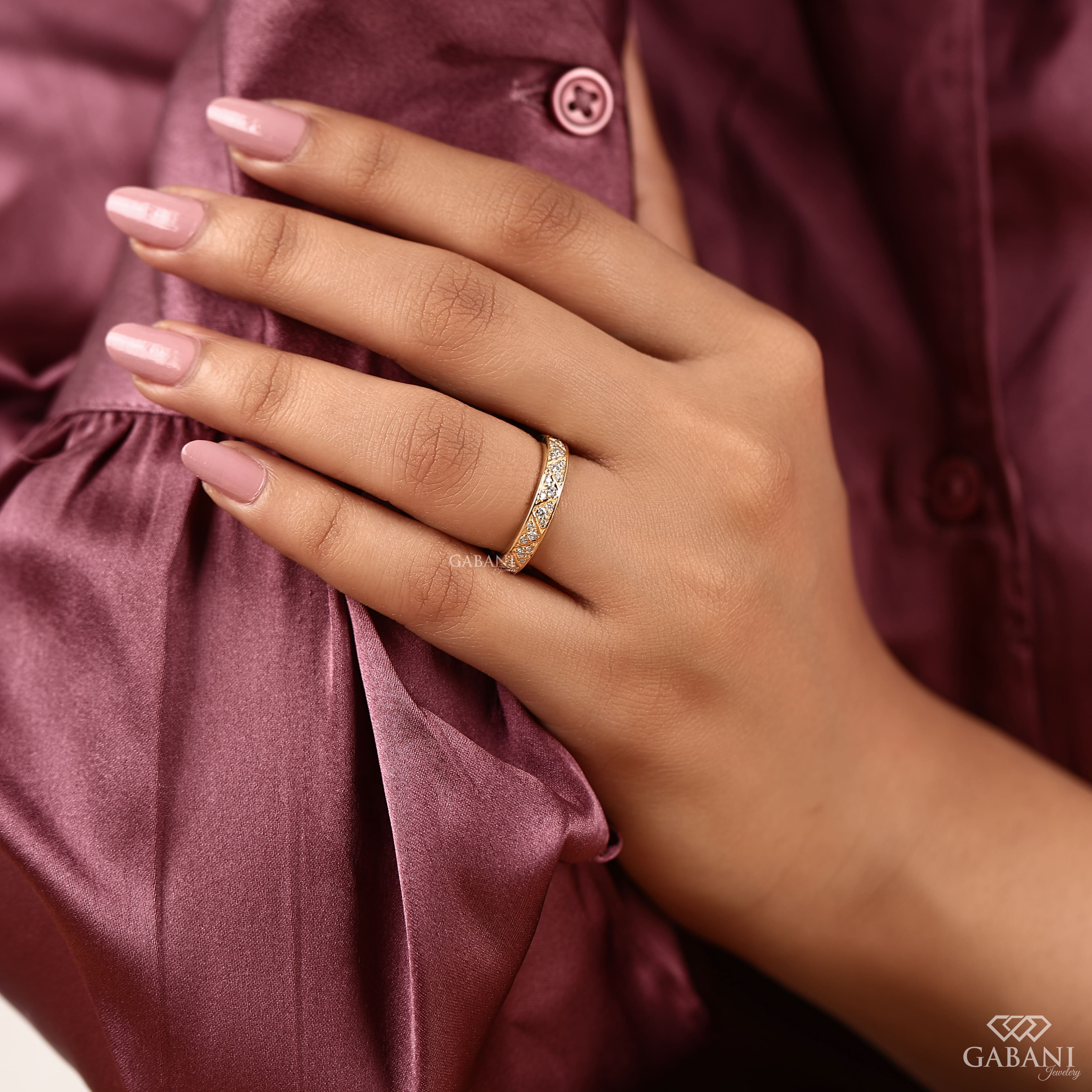 Round lab grown diamond wedding band with geometric triangular pattern and polished yellow gold setting.