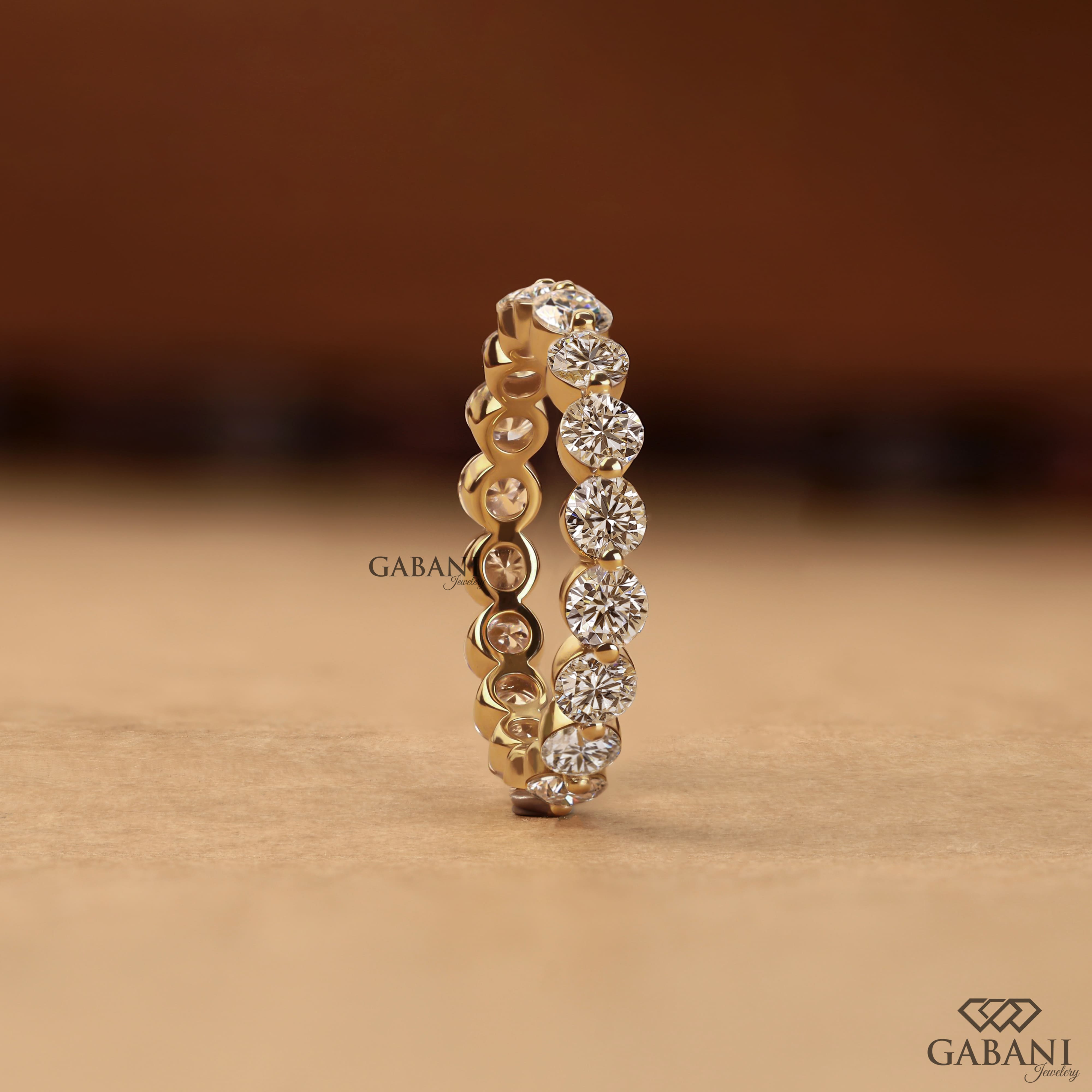 Round lab grown diamond shared prong full eternity wedding band in yellow gold with continuous diamond setting.