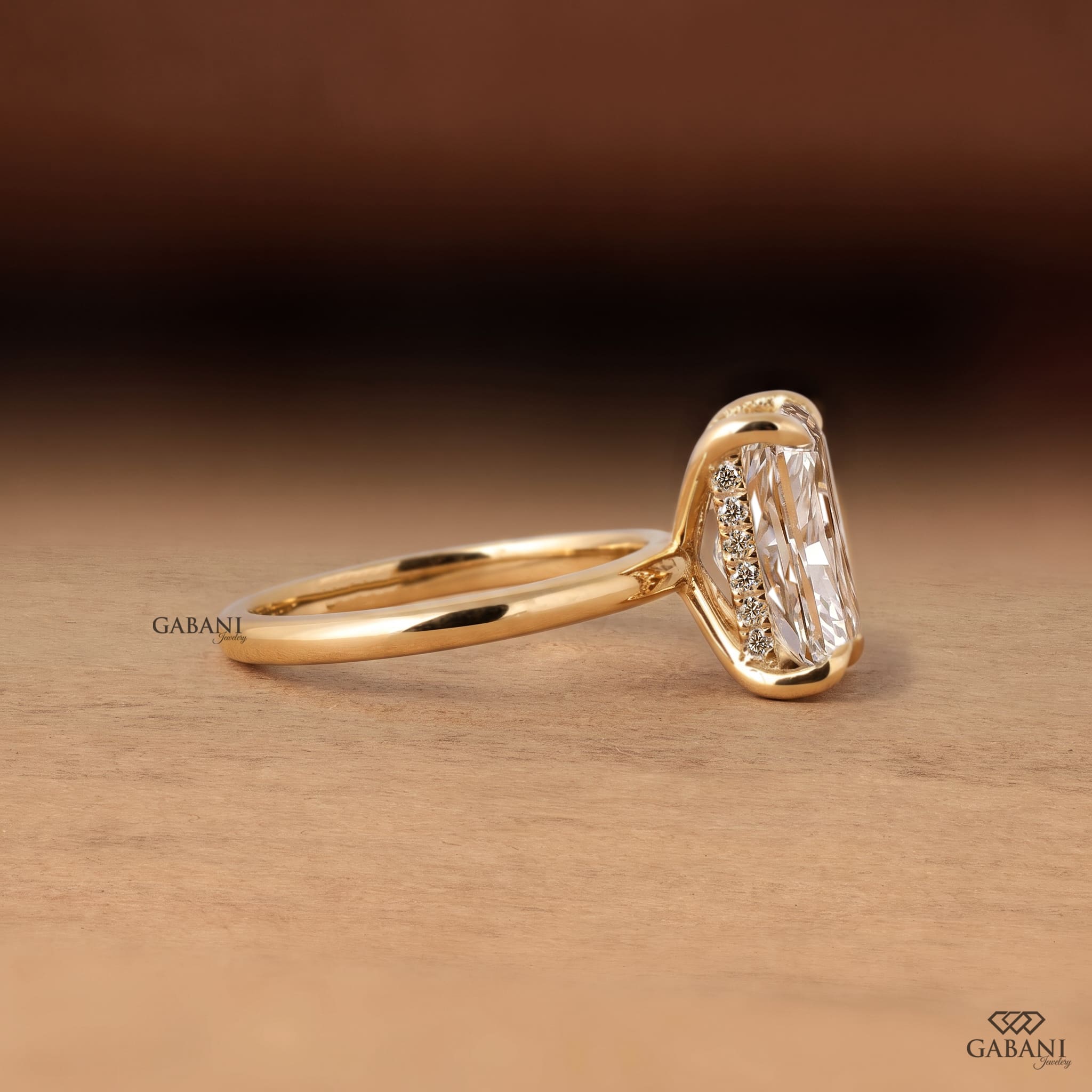 Radiant cut lab grown diamond engagement ring in 18K yellow gold with hidden halo, four claw prong setting and round diamond accents.