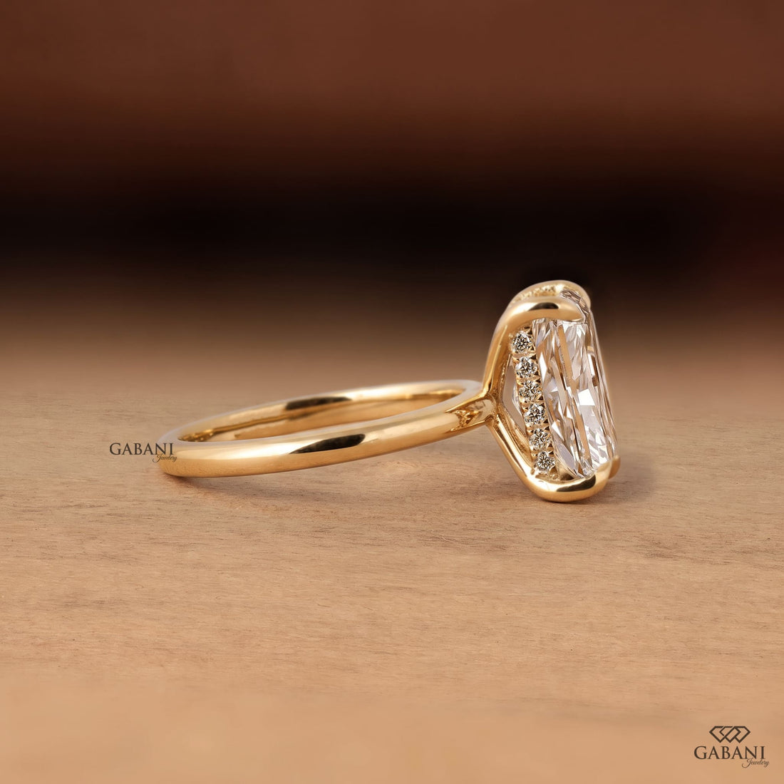Radiant cut lab grown diamond engagement ring in 18K yellow gold with hidden halo, four claw prong setting and round diamond accents.