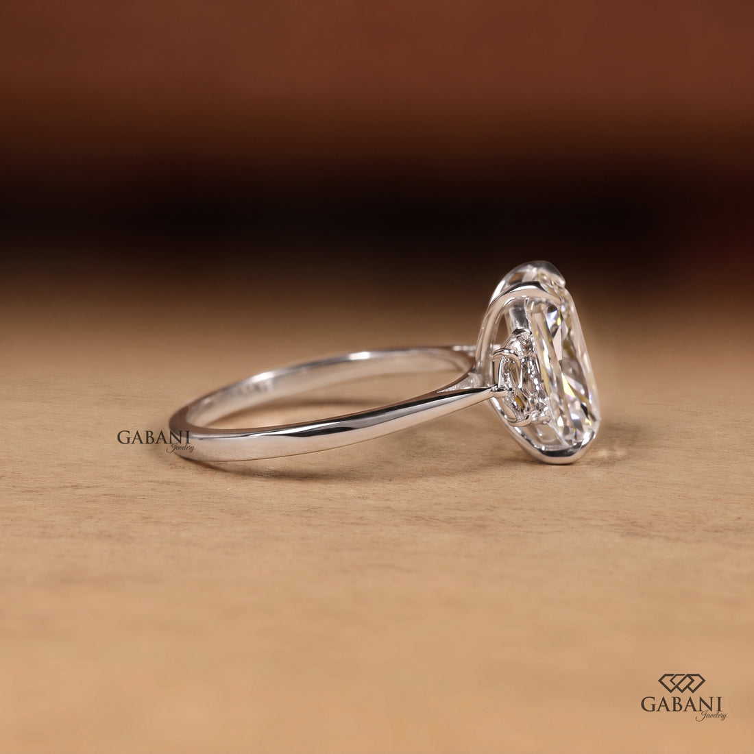Cushion cut lab grown diamond three stone engagement ring with pear cut side diamonds in gold setting