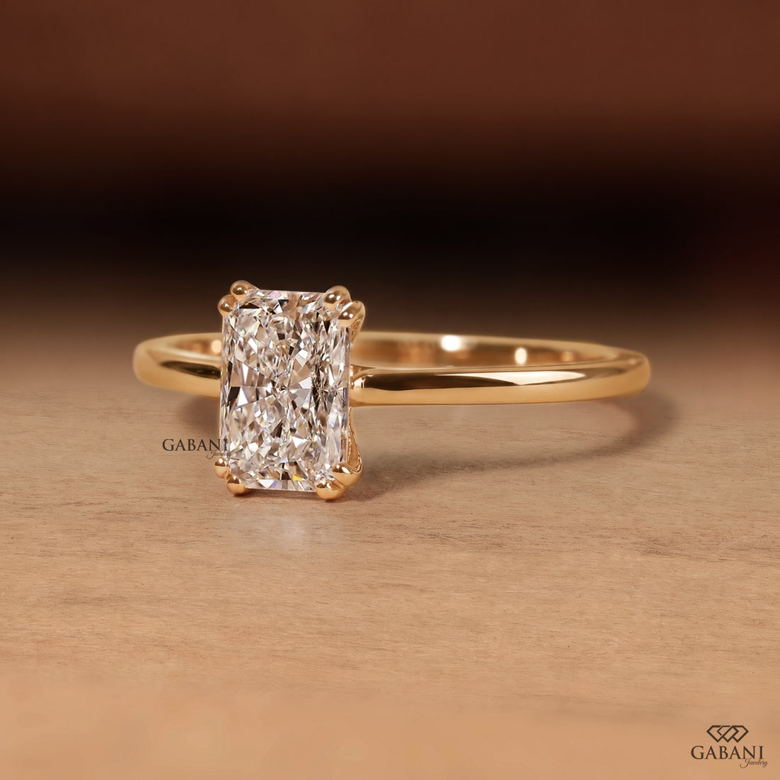 Radiant cut lab grown diamond engagement ring in 18K yellow gold with double claw prongs, elongated center stone and a slim polished solitaire band.