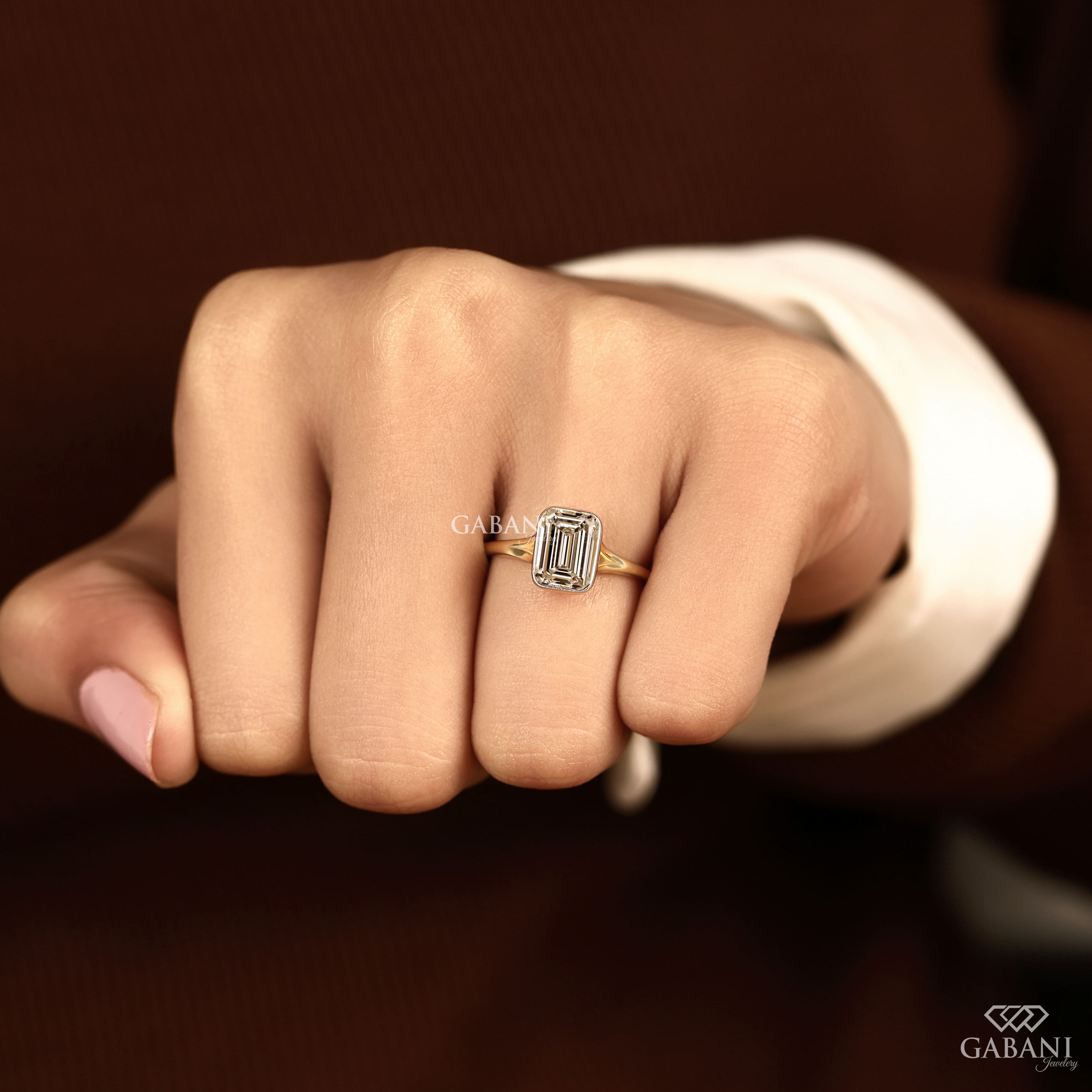 emerald cut diamond solitaire engagement ring with full bezel setting in yellow gold