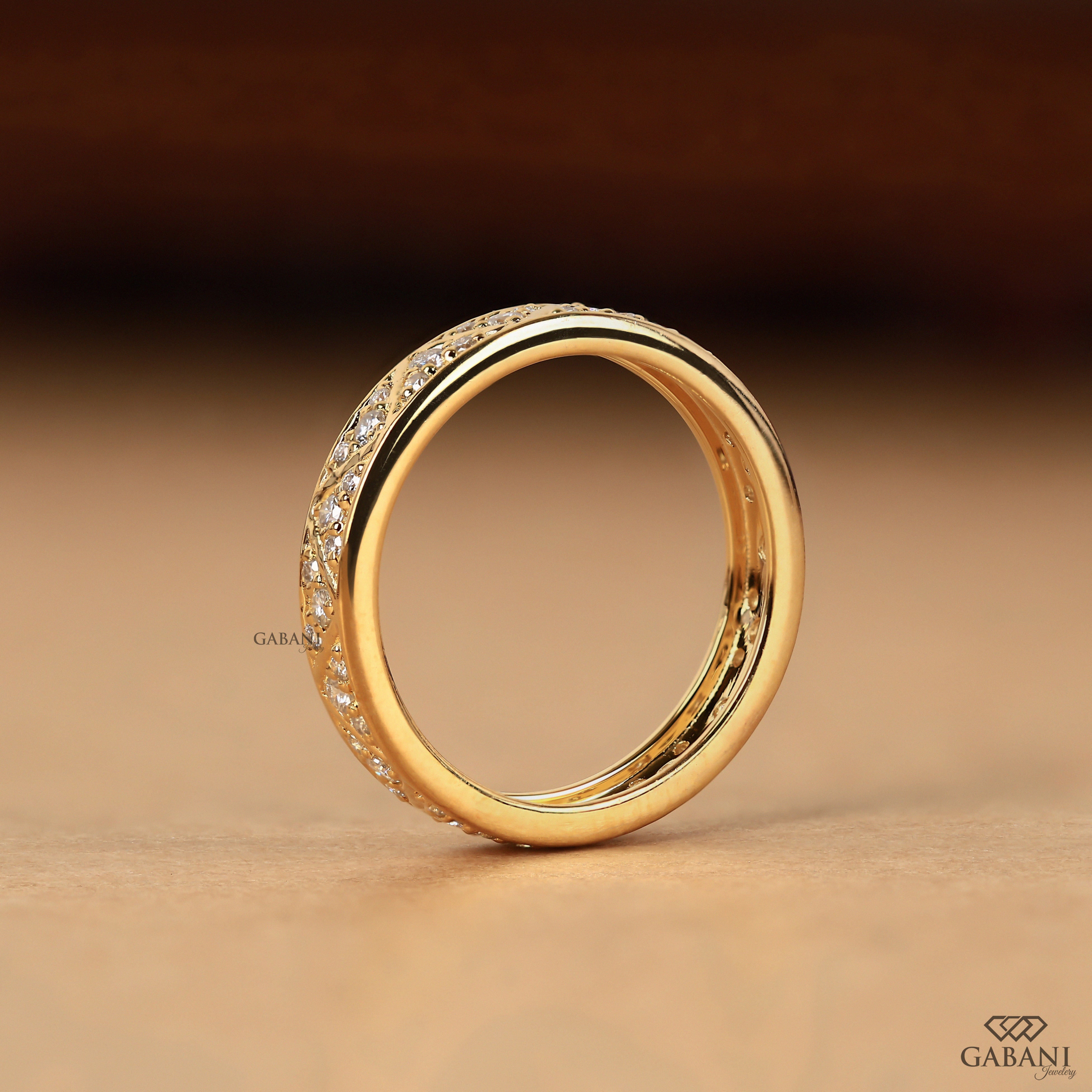 Round lab grown diamond wedding band with geometric triangular pattern and polished yellow gold setting.