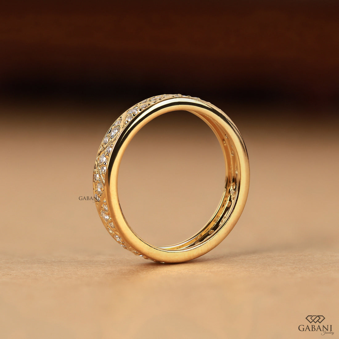 Round lab grown diamond wedding band with geometric triangular pattern and polished yellow gold setting.