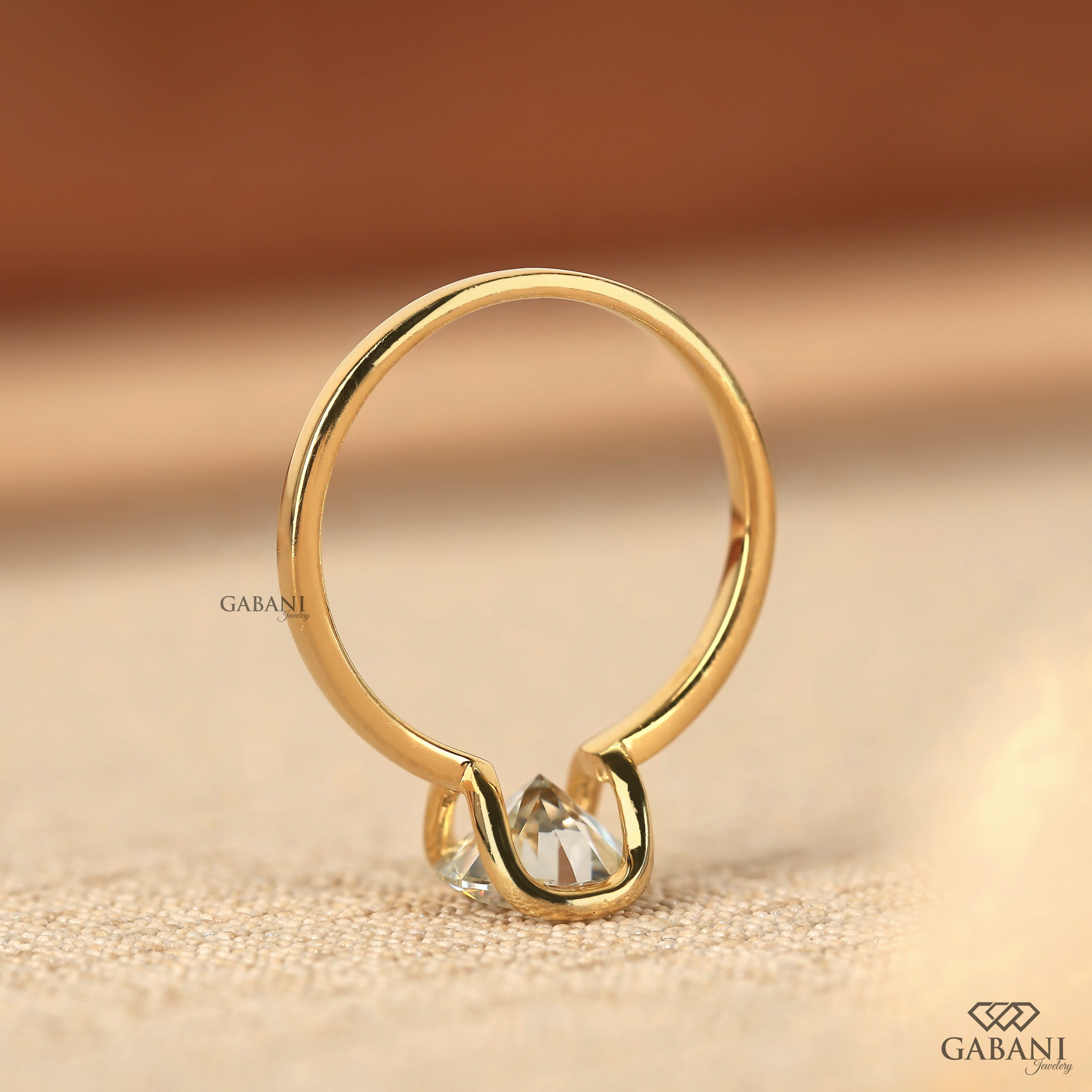 Round diamond half bezel solitaire engagement ring in yellow gold with a slim straight polished band.