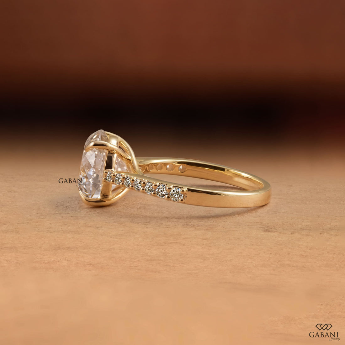 Round Portuguese cut lab grown diamond cathedral engagement ring in yellow gold with a four-prong center setting and pave diamond shoulders.