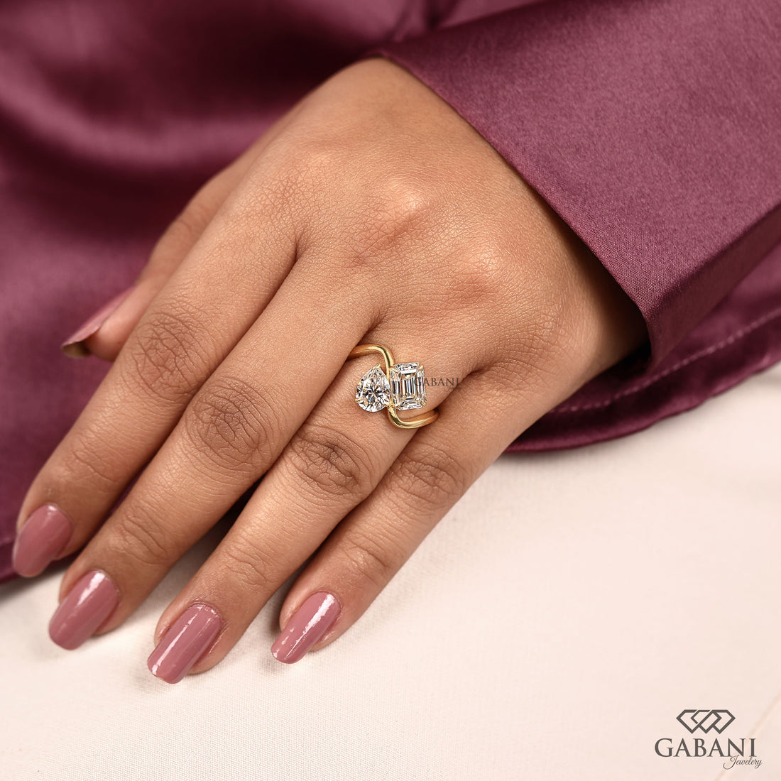 Pear and emerald cut lab grown diamond Toi et Moi ring with a curved yellow gold band, designed for engagement, anniversary, proposal, and statement wear.
