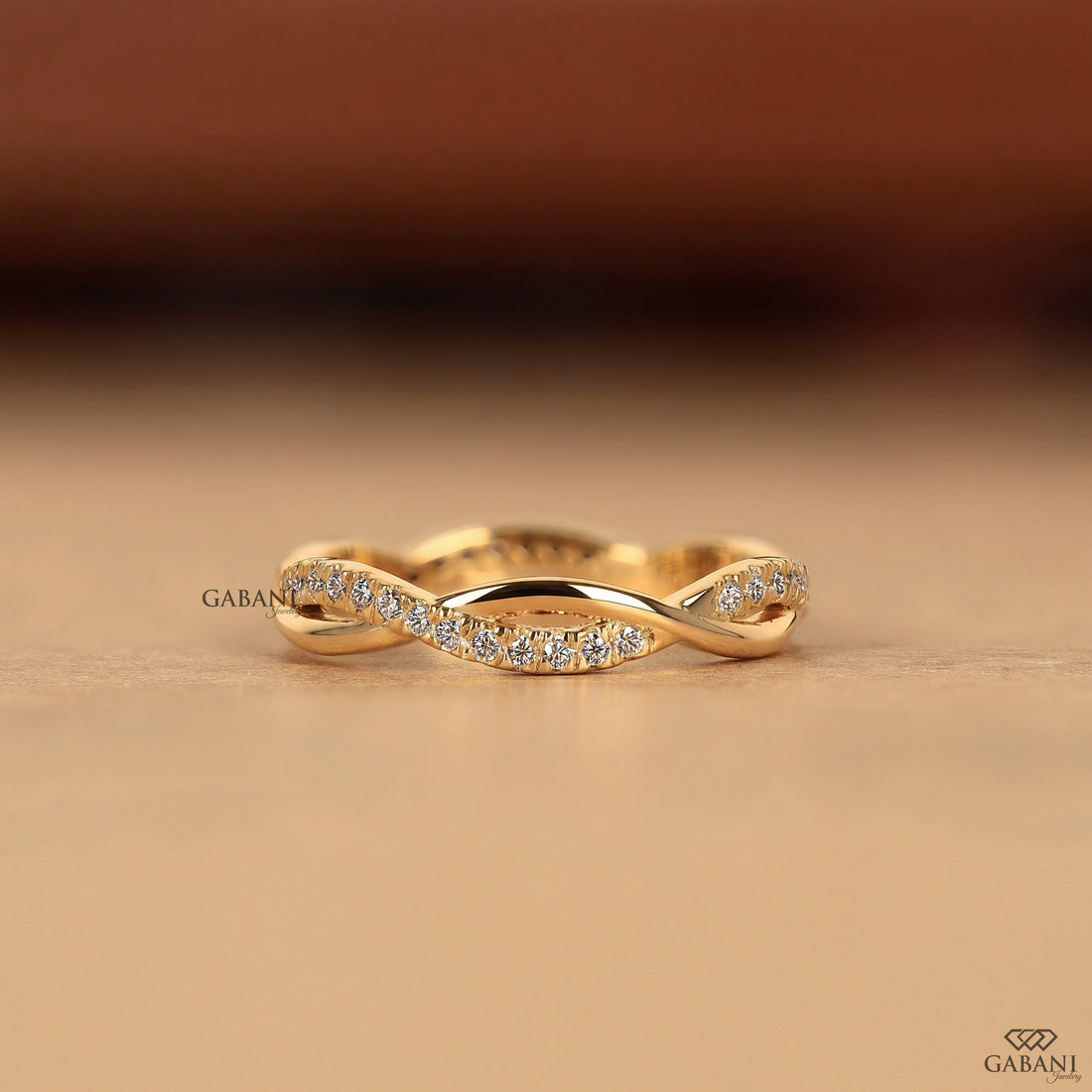 Twisted full eternity lab grown diamond band in yellow gold with round cut diamonds and an infinity inspired crossover design for wedding, anniversary, and stackable wear.