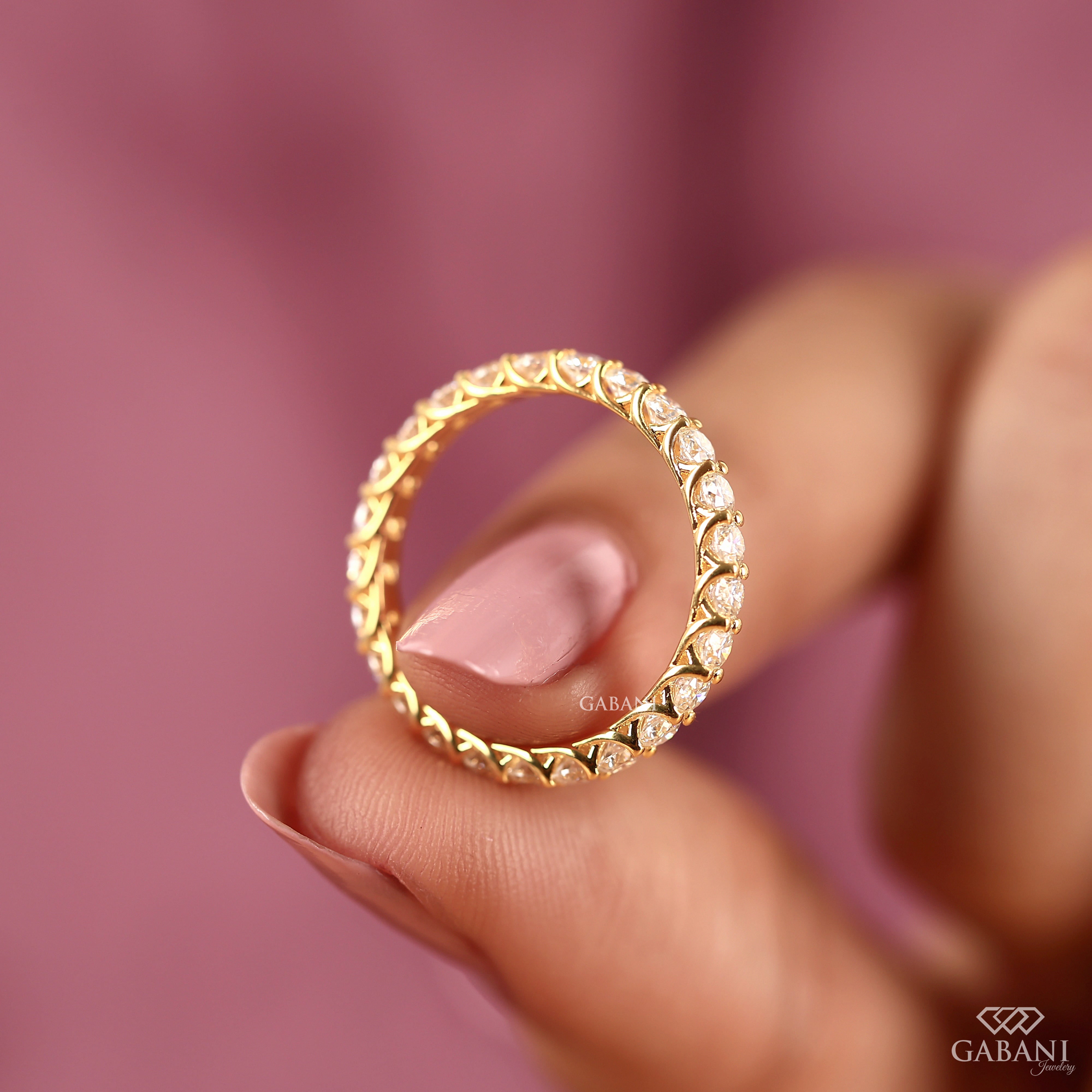 a round lab grown diamond full eternity band in 14K yellow gold, featuring sparkling shared prong set diamonds in a classic wedding band design by Gabani Jewelry.