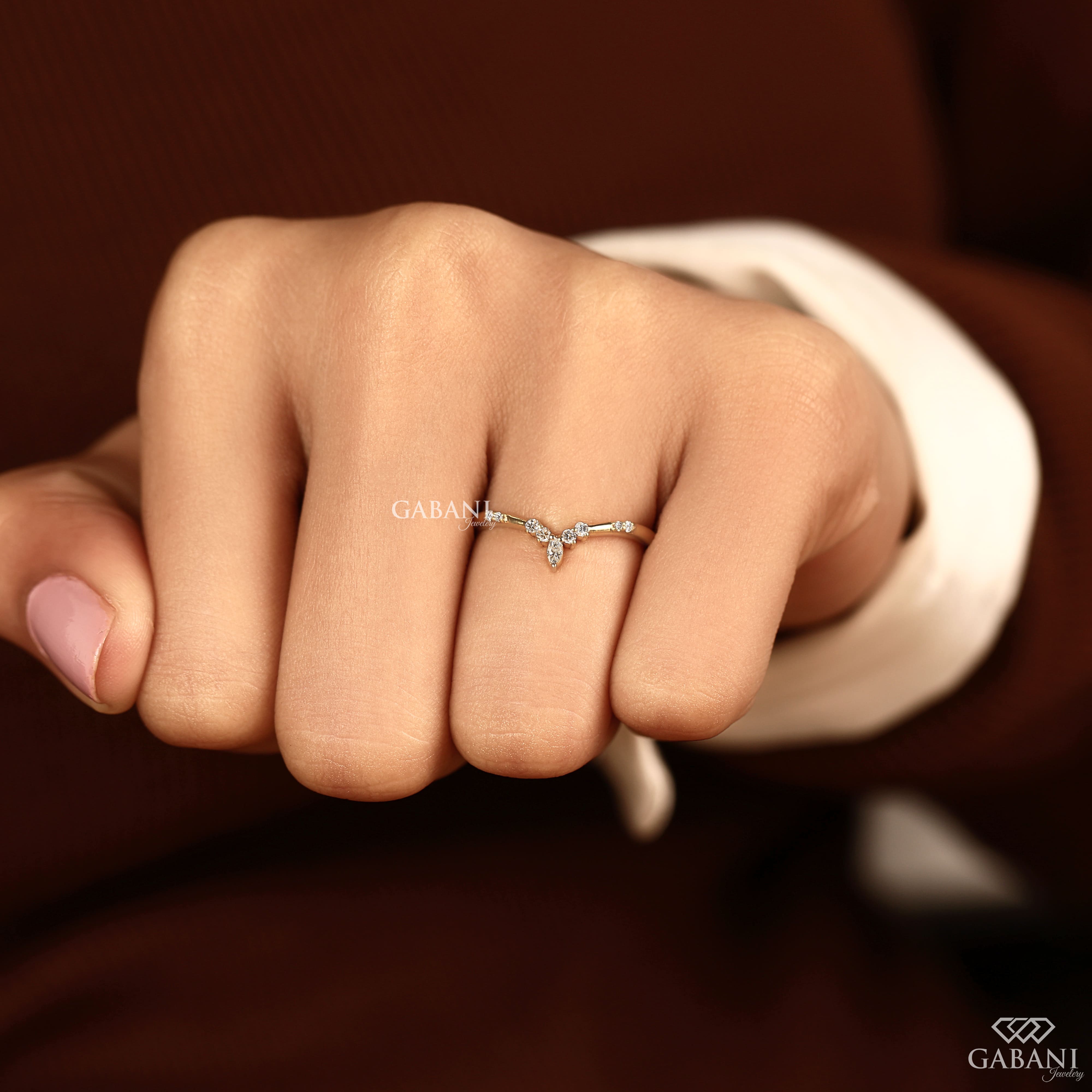 Marquise and round cut lab grown diamond curved wedding band in yellow gold with V shaped contour design for stacking with an engagement ring.