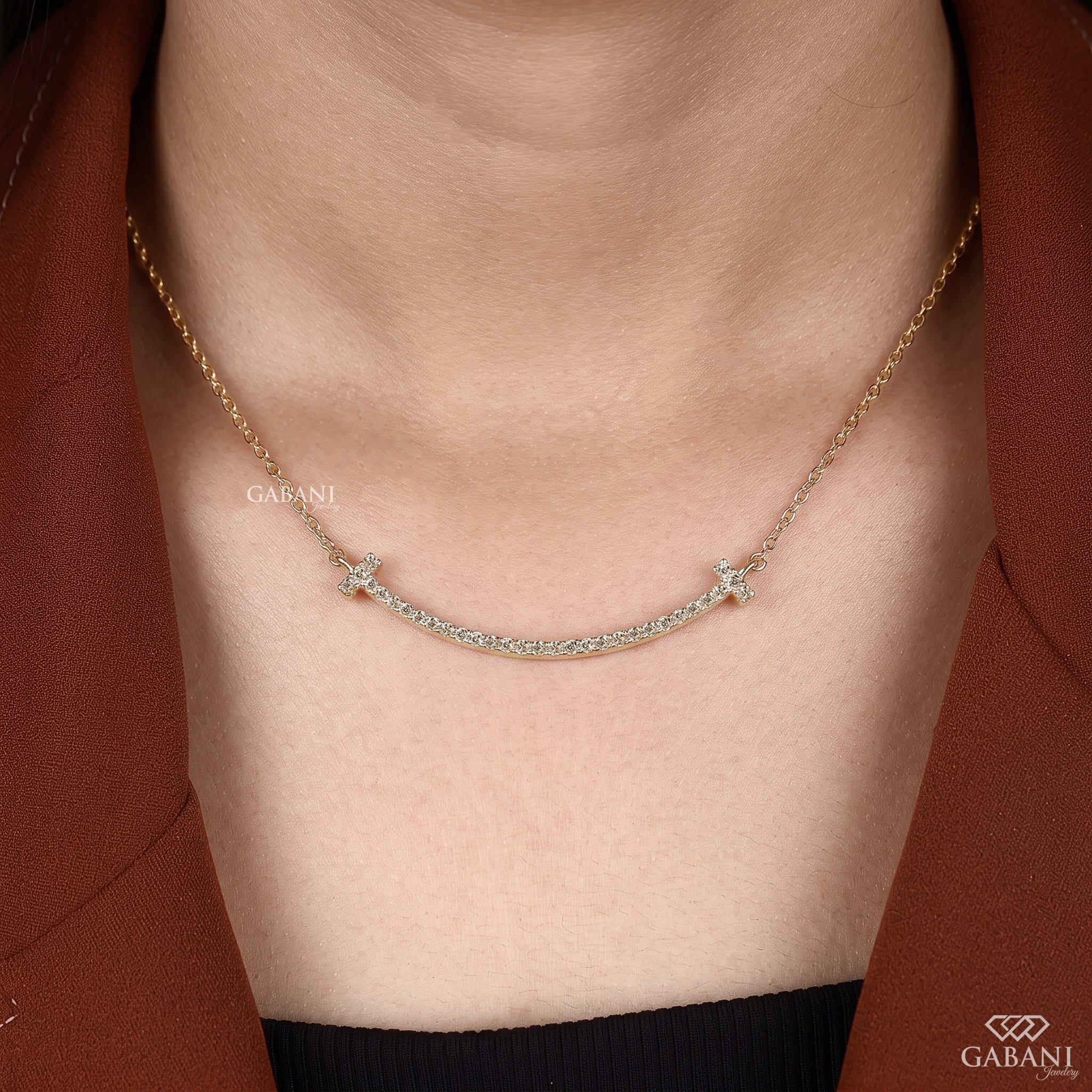 Curved bar lab grown diamond necklace in yellow gold featuring round pavé set diamonds, T-shaped ends and a delicate gold chain.