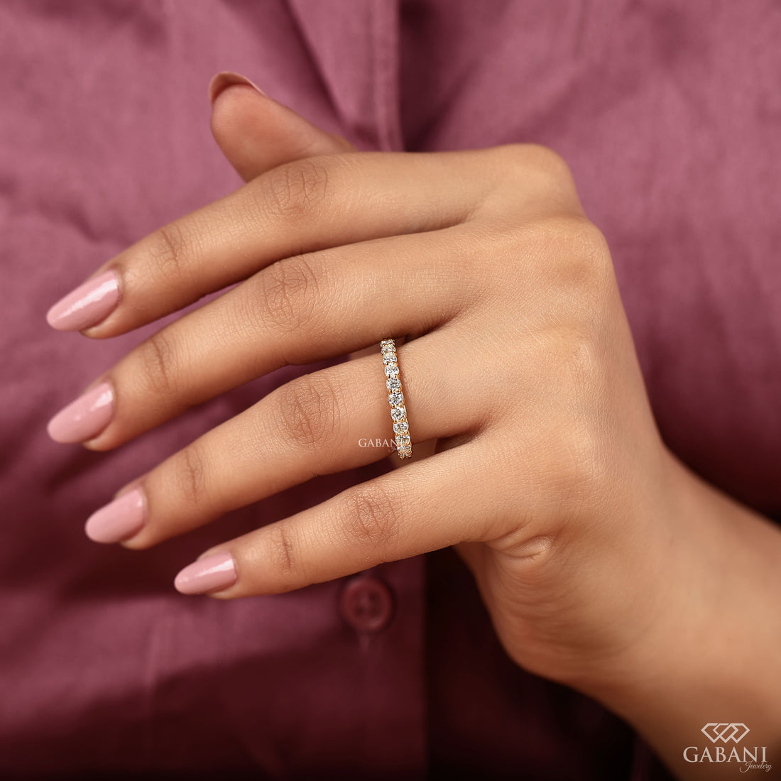 a round lab grown diamond full eternity band in 14K yellow gold, featuring sparkling shared prong set diamonds in a classic wedding band design by Gabani Jewelry.