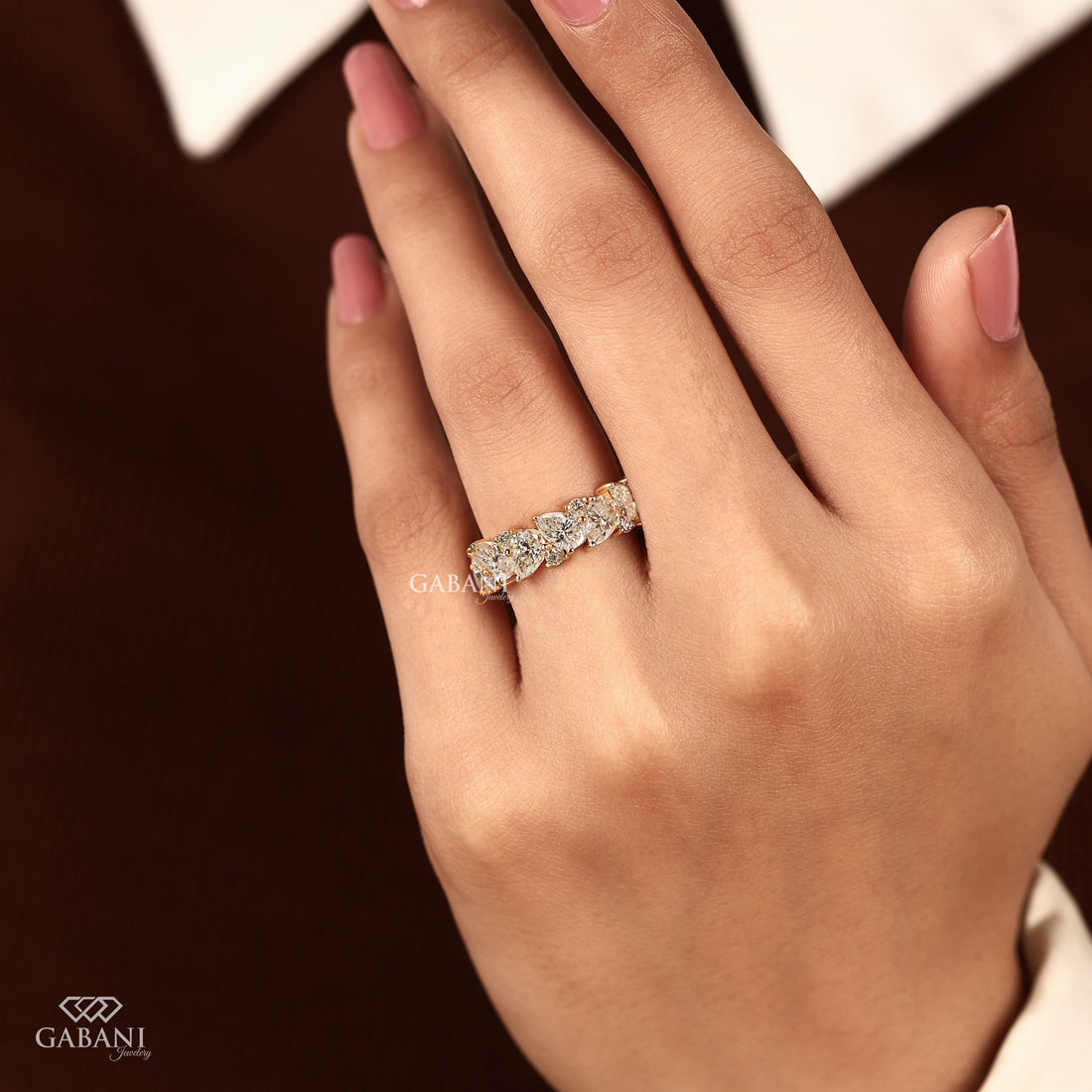 Pear and round lab grown diamond half eternity wedding band in yellow gold with alternating prong set diamond design.