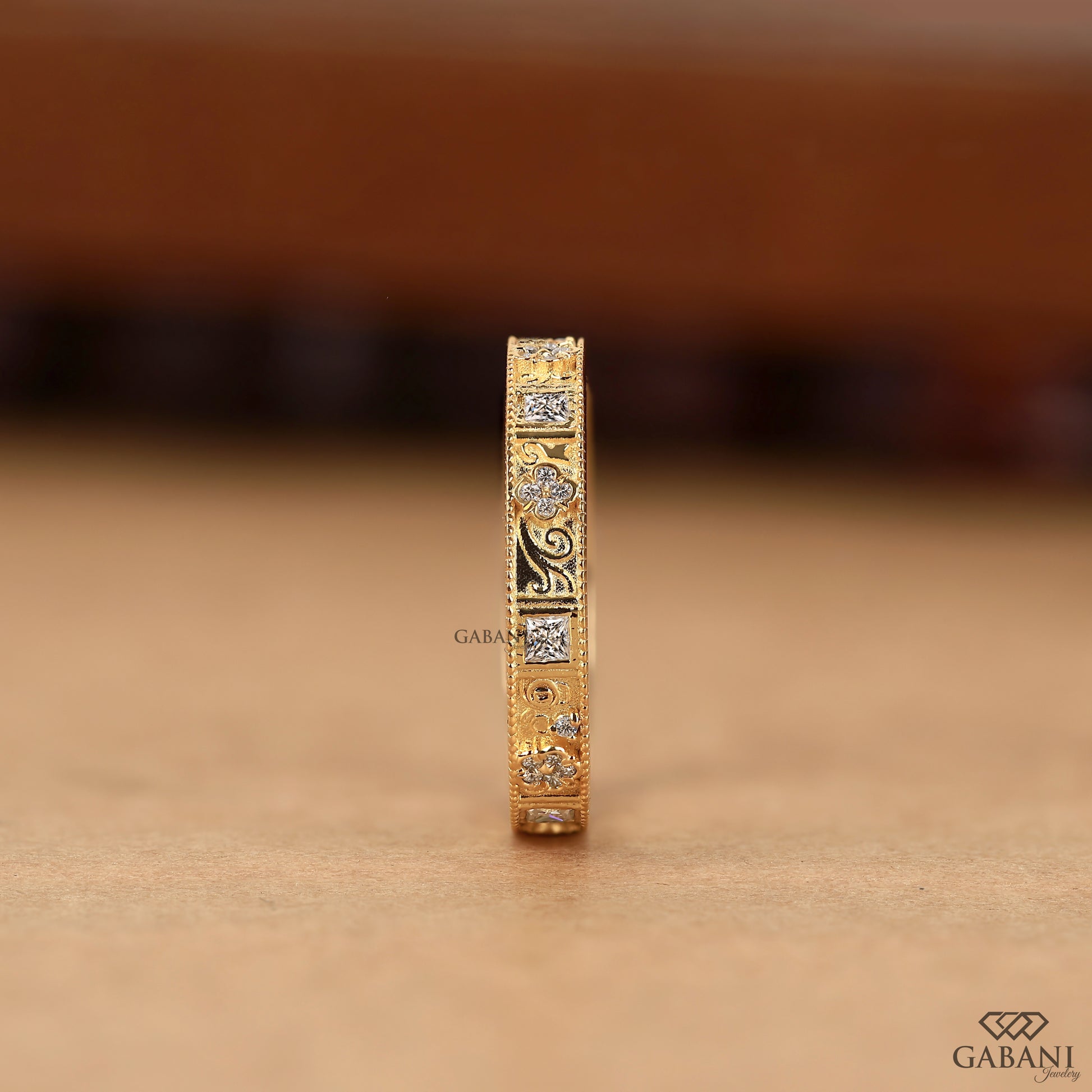 art deco eternity band with princess cut and round lab grown diamonds in yellow gold with milgrain detail