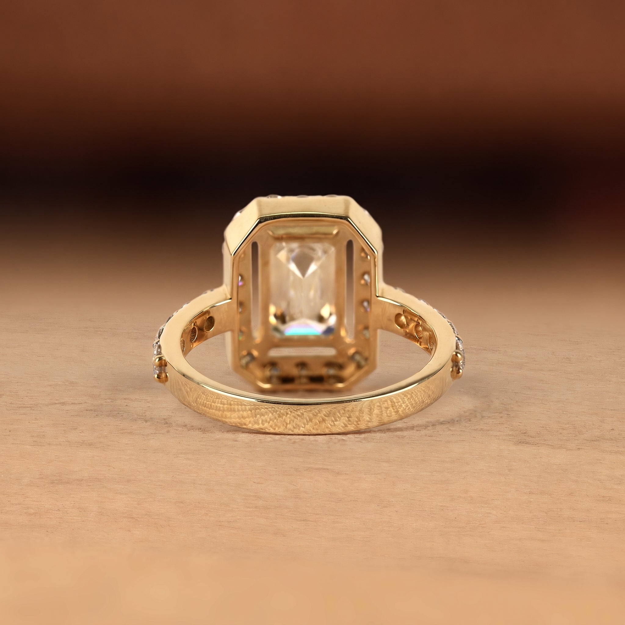 Emerald cut lab grown diamond engagement ring with round diamond halo, pave side stones, yellow gold band, IGI certified EF color VS1 clarity.