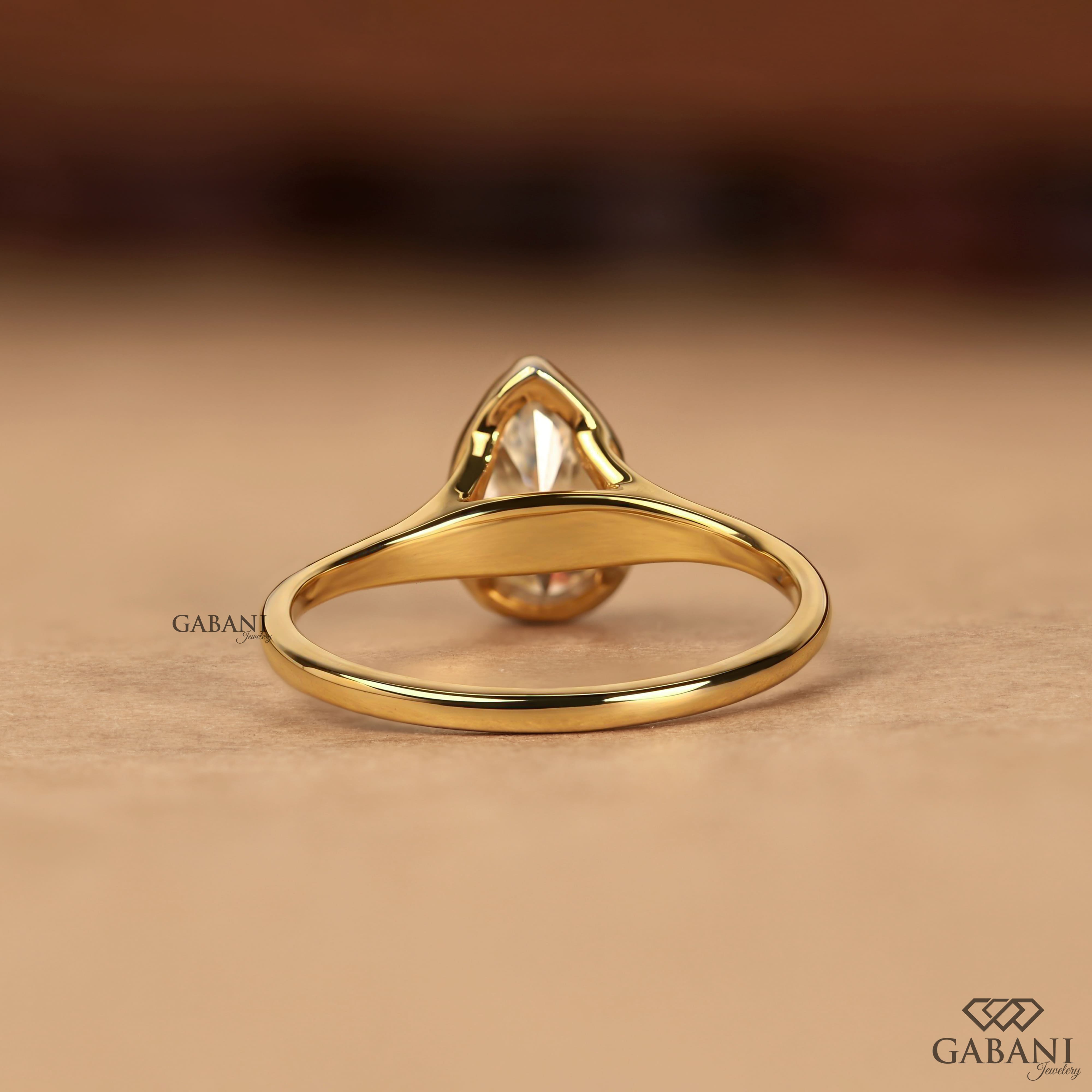 Pear cut diamond solitaire engagement ring with full bezel setting in polished yellow gold