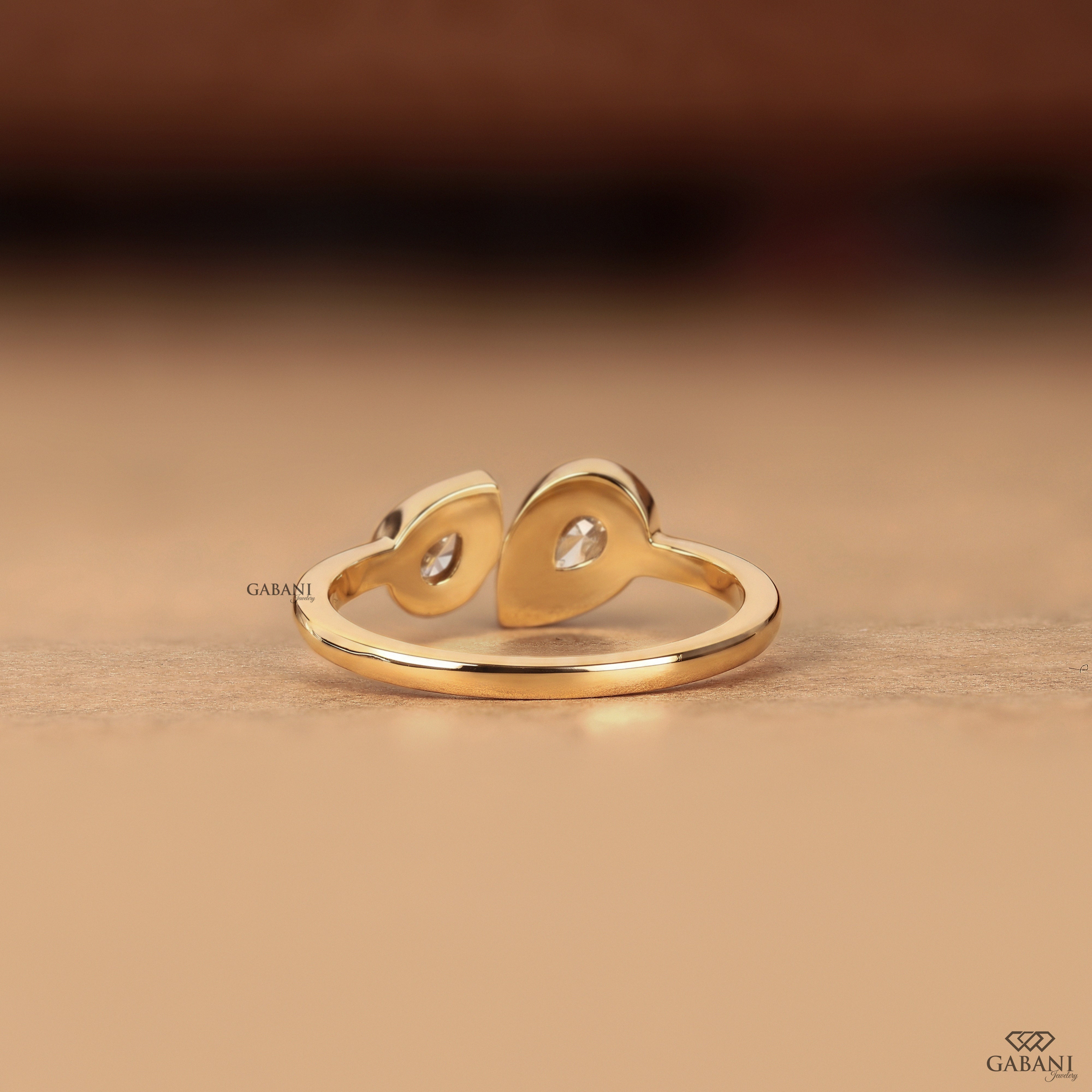 Back view of a pear cut lab grown diamond engagement ring showing the clean bezel set two stone design