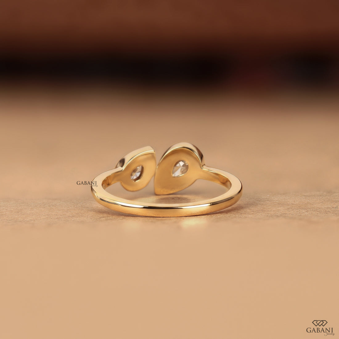 Back view of a pear cut lab grown diamond engagement ring showing the clean bezel set two stone design