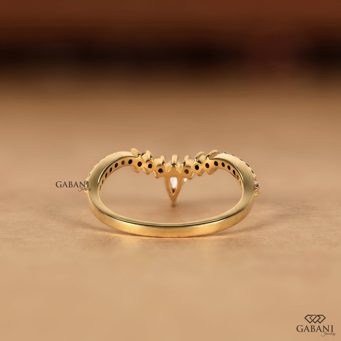 Back view of curved solid gold chevron wedding band with pear cut lab grown diamond