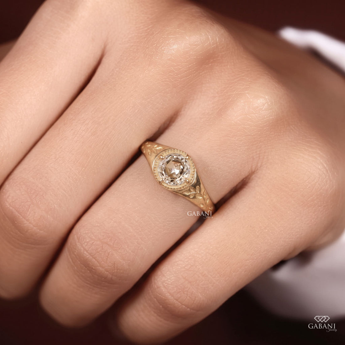 Round rose cut lab grown diamond signet ring with four prong setting, leaf engraving, beaded detailing and yellow gold band.