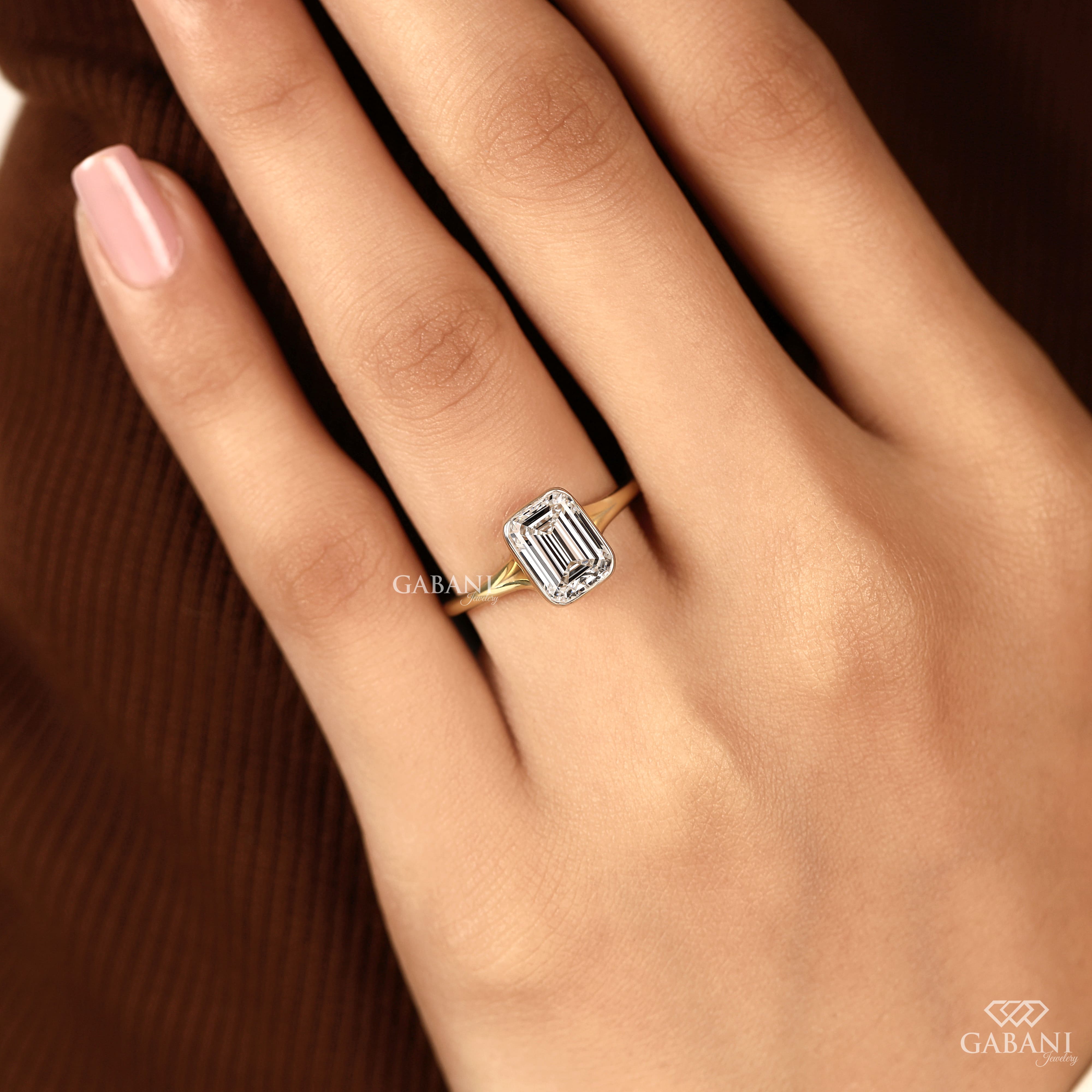 emerald cut diamond solitaire engagement ring with full bezel setting in yellow gold