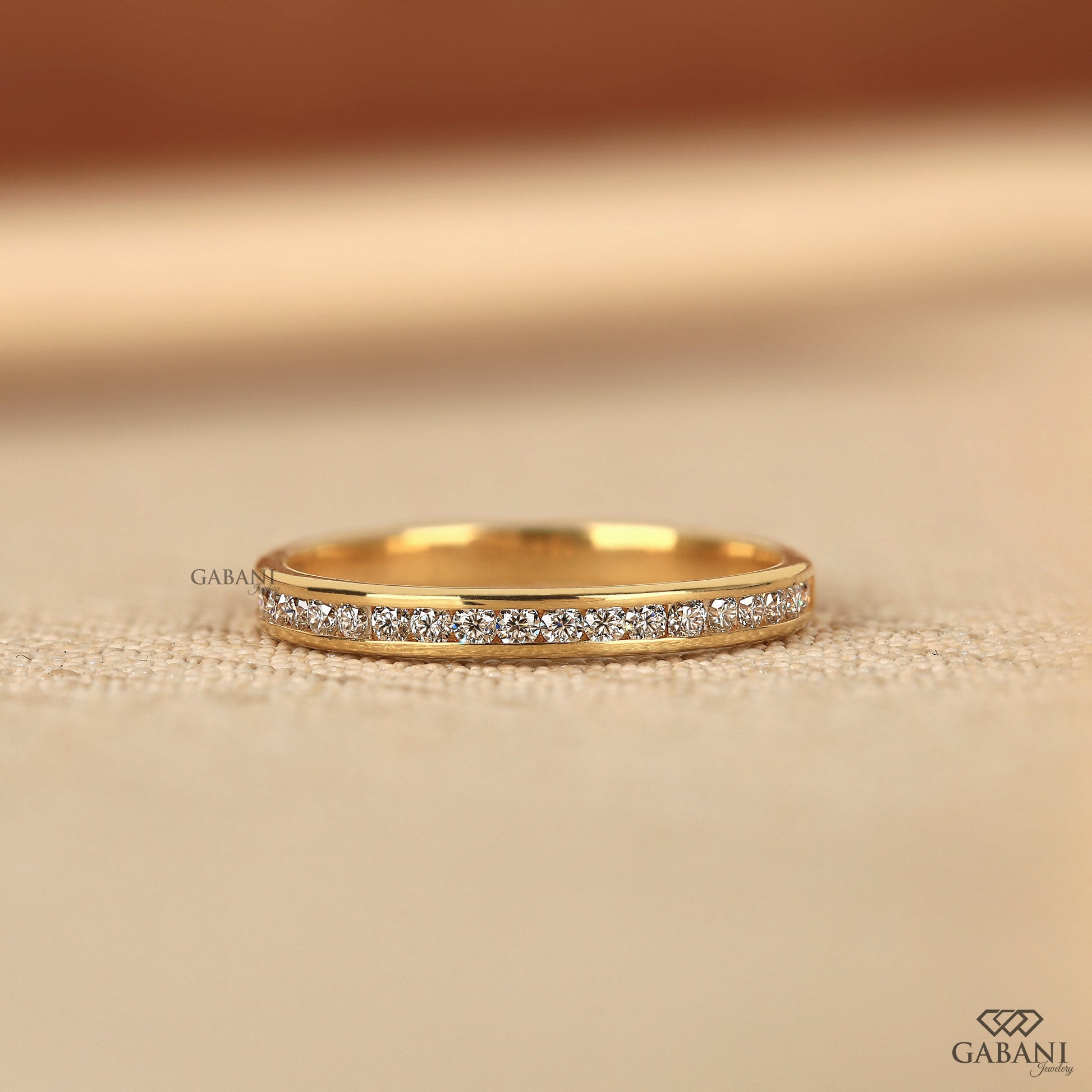 thin yellow gold band with channel set lab grown diamonds in a minimal half eternity design