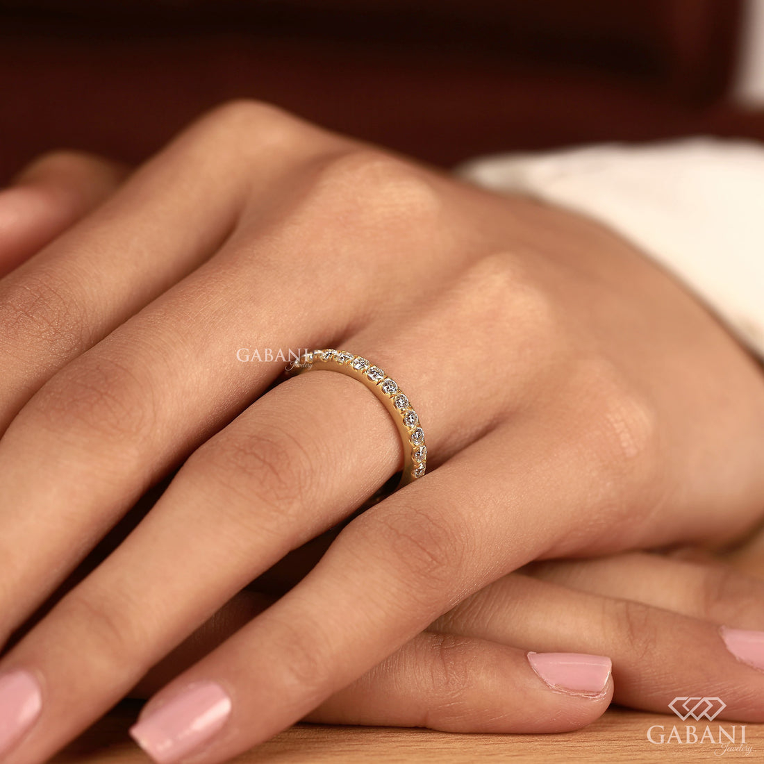 Round cut lab grown diamond eternity wedding band in yellow gold with continuous diamond setting and classic bridal style.