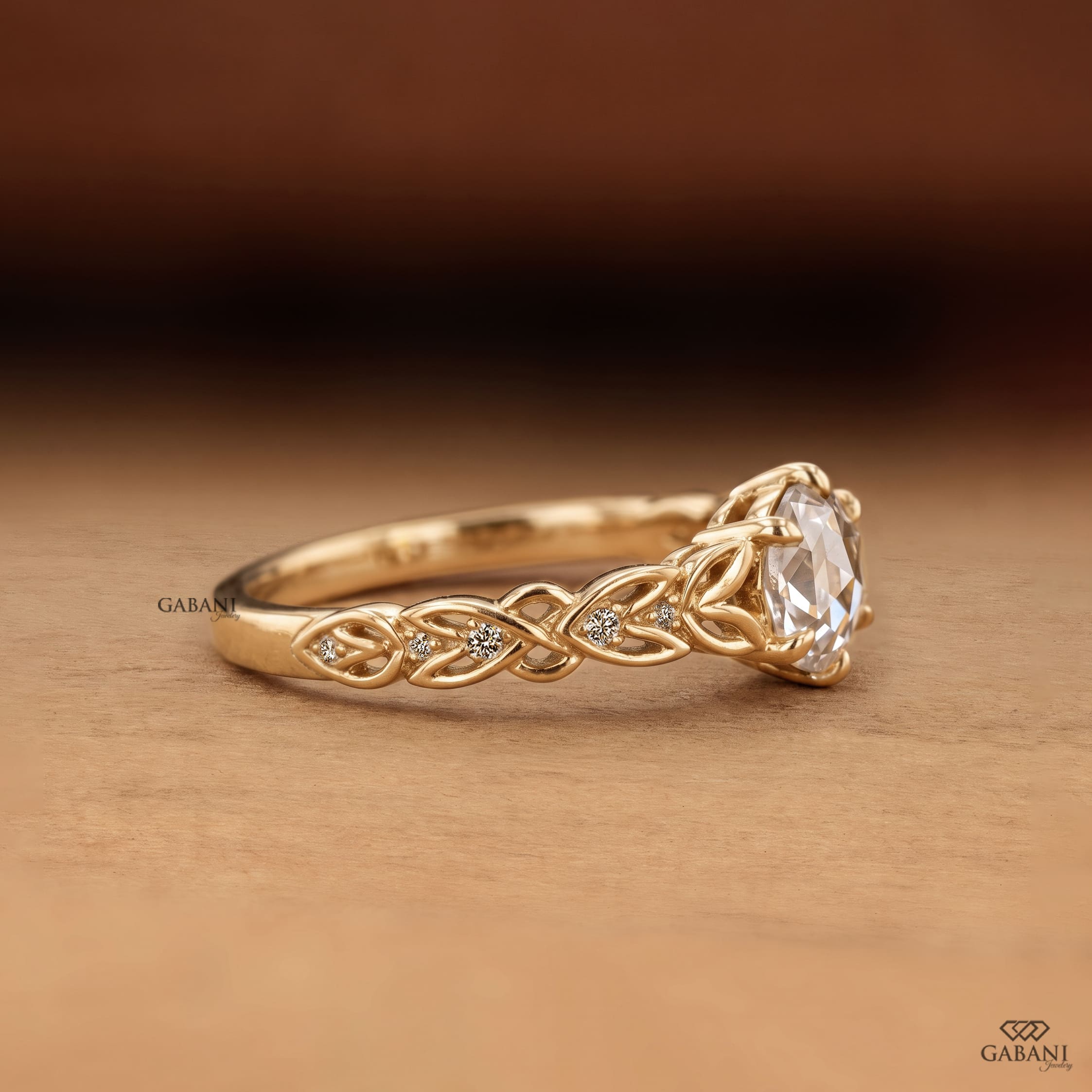 Oval rose cut lab grown diamond engagement ring with leaf vine band, round diamond accents, and six claw prong setting in 14K yellow gold.