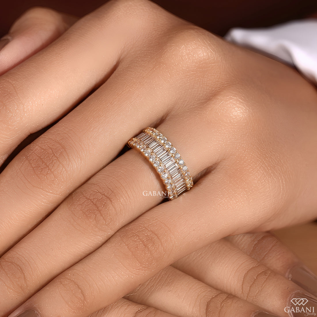 Close view of the wide band showcasing standing baguette and round lab grown diamonds in yellow gold