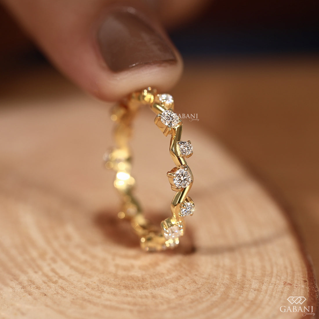 a round lab grown diamond zigzag eternity band in 14K yellow gold, featuring alternating round diamonds in a unique wave design.