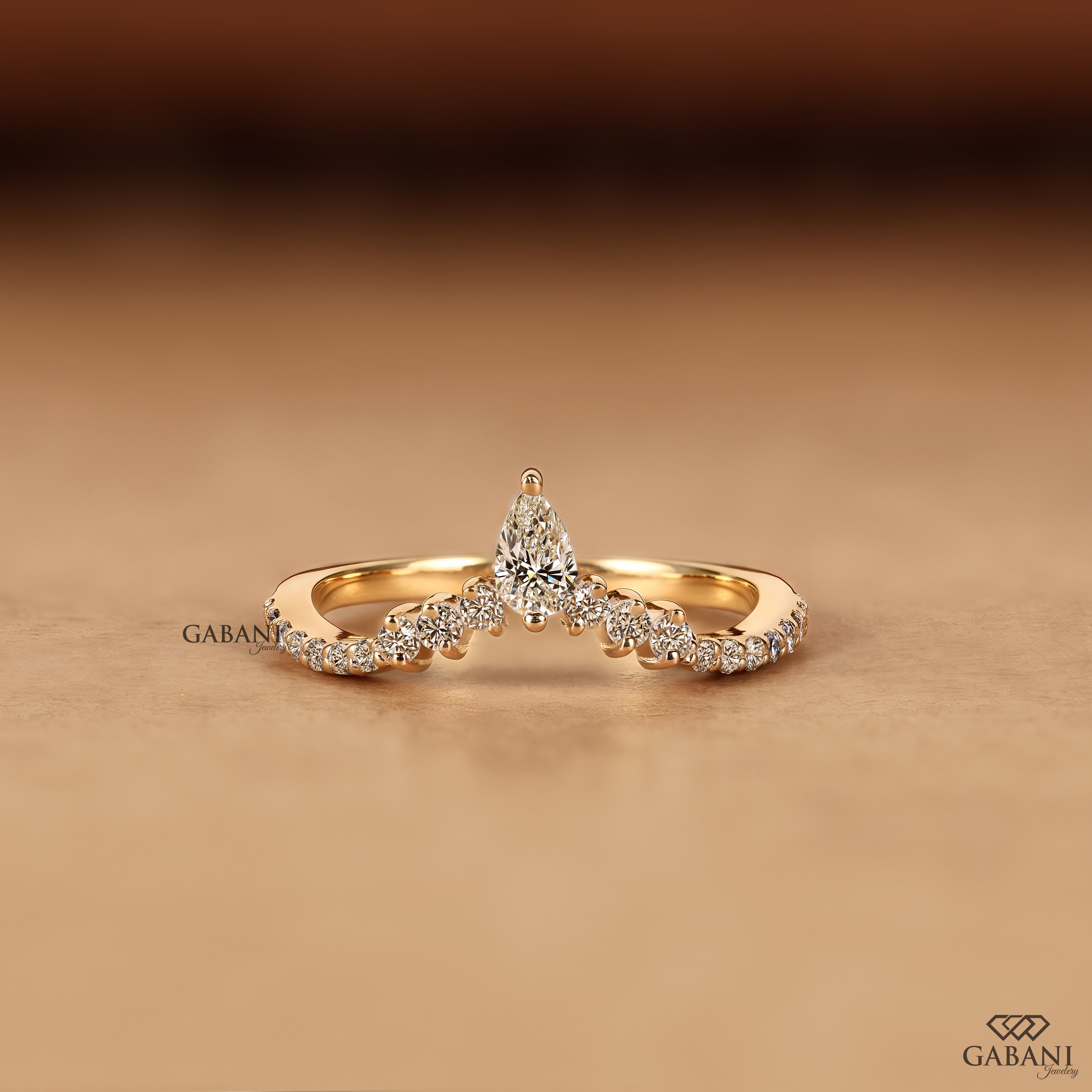 Front view of Gabani Jewelry V shaped chevron wedding band with pear cut lab grown diamond in solid gold