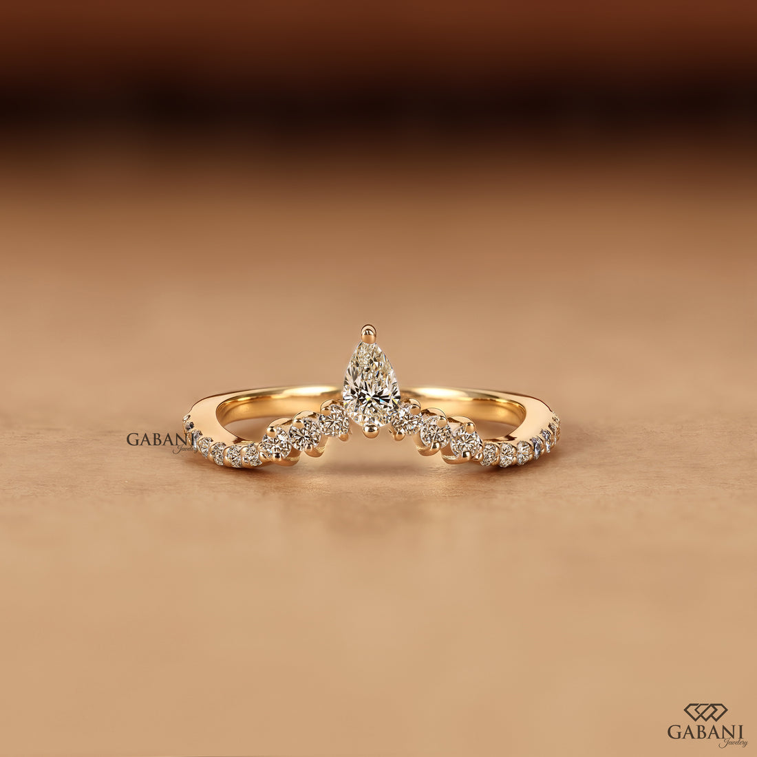 Front view of Gabani Jewelry V shaped chevron wedding band with pear cut lab grown diamond in solid gold