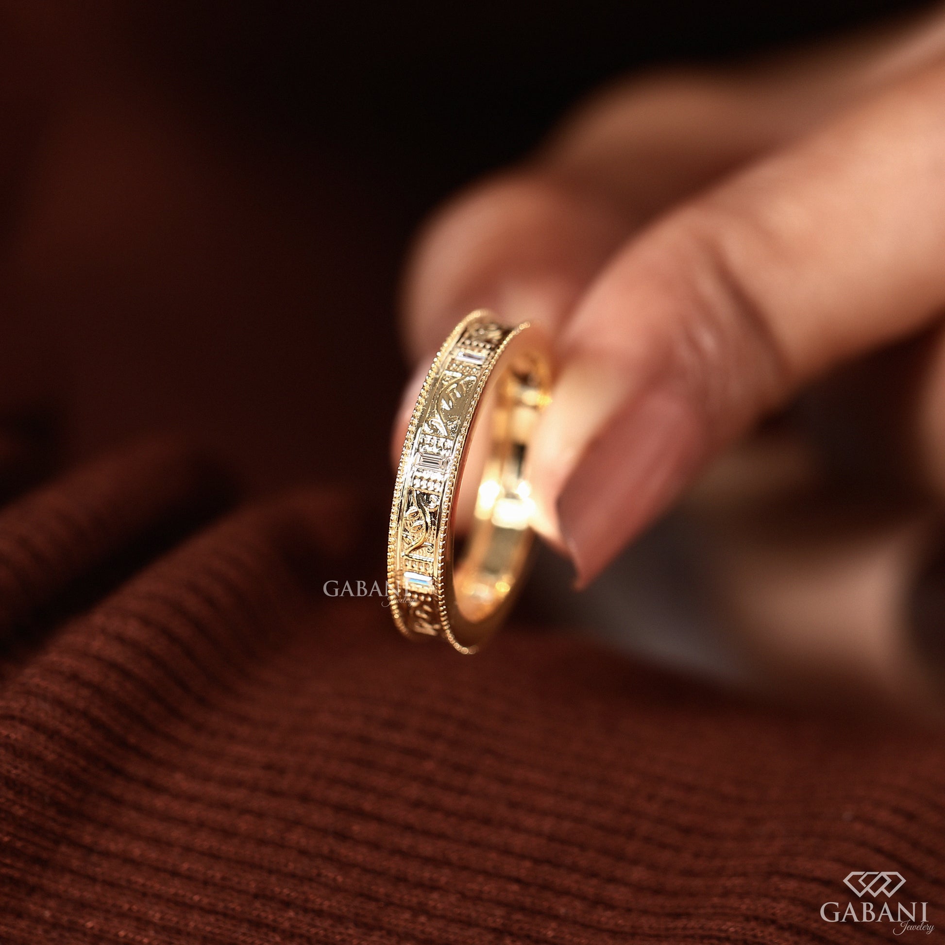 GABANIJEWELRY handmade milgrain wedding band standing upright, solid gold ring with engraved leaf design and vintage art deco style