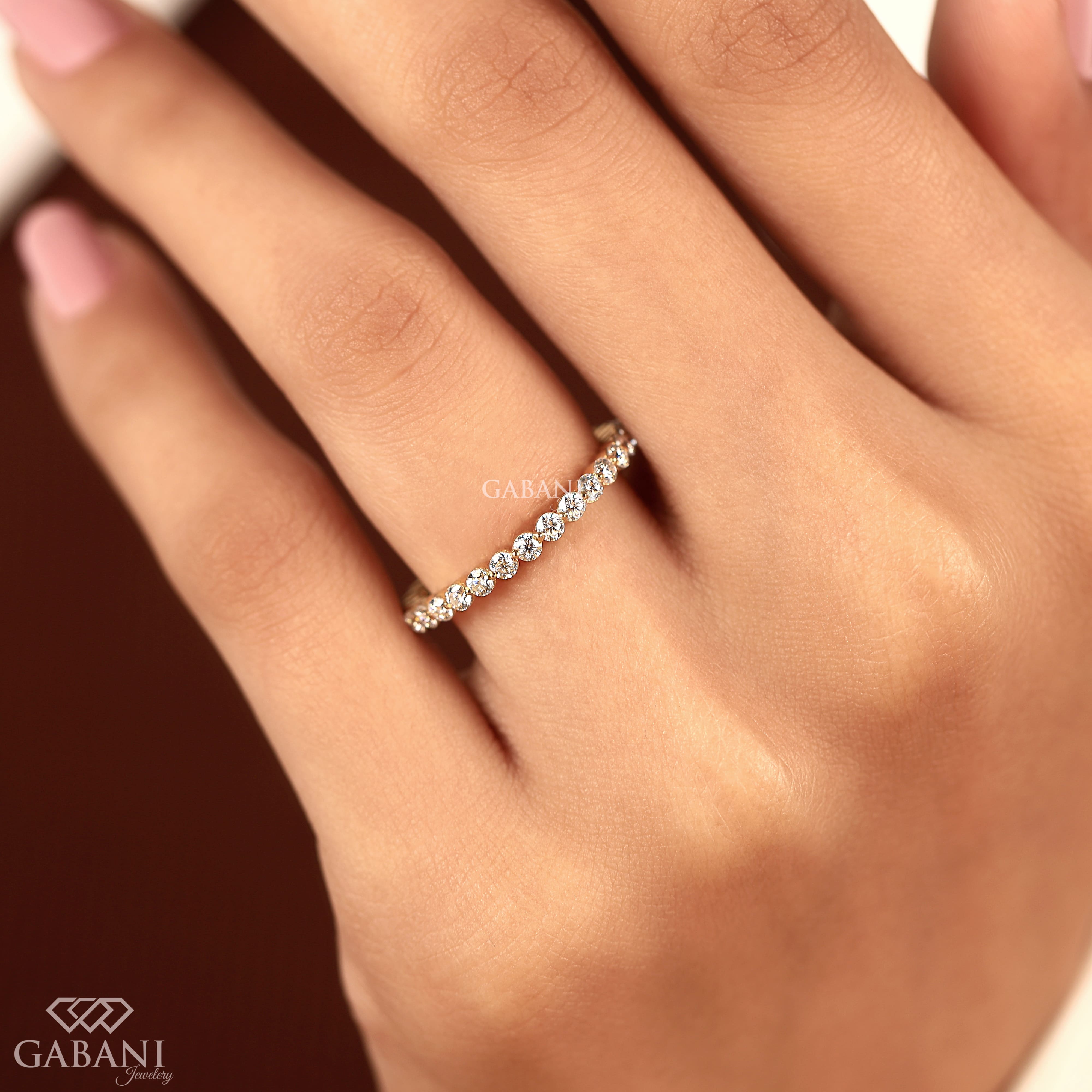 Round cut lab grown diamond full eternity wedding band in yellow gold with shared prong setting and continuous diamond design.