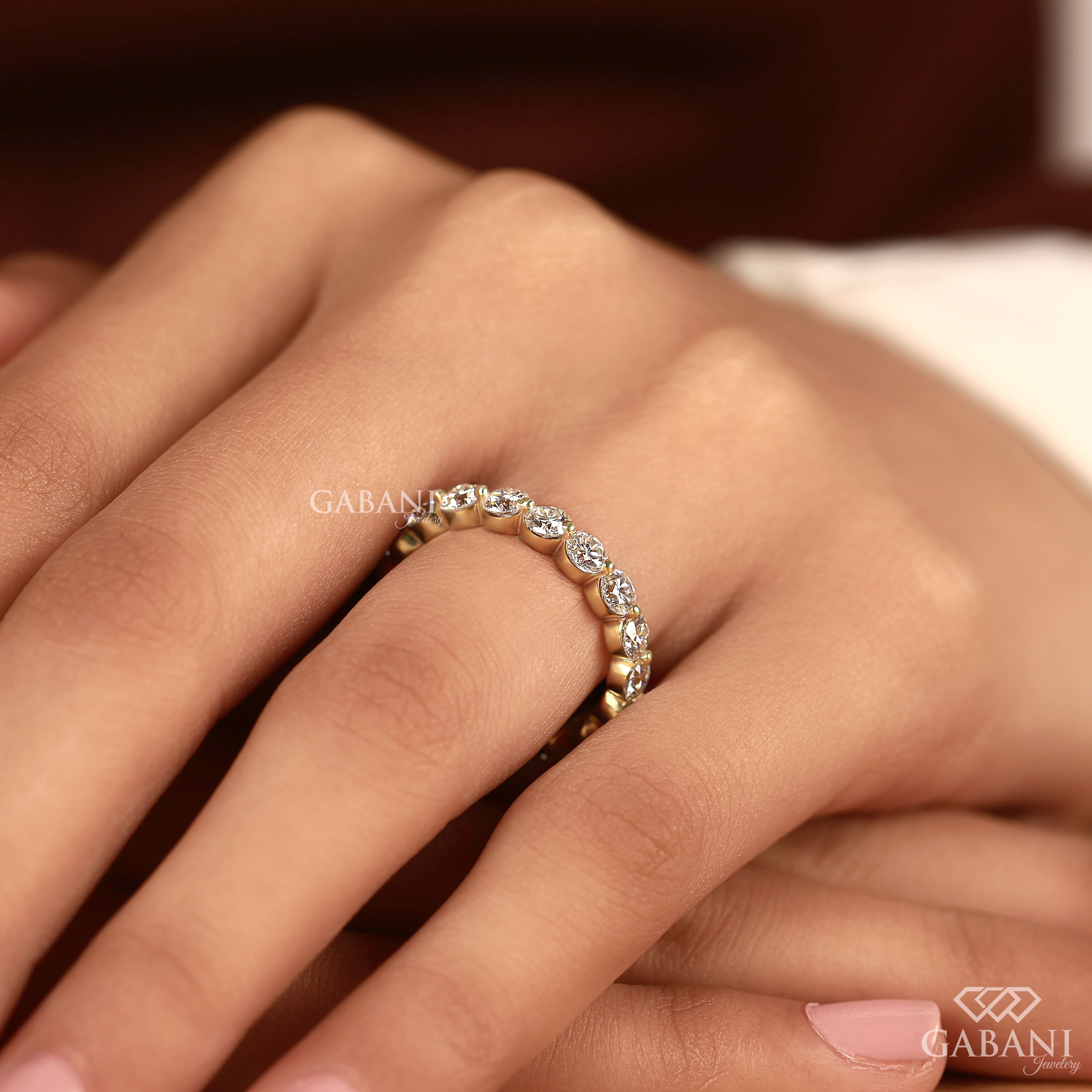 Round lab grown diamond shared prong full eternity wedding band in yellow gold with continuous diamond setting.