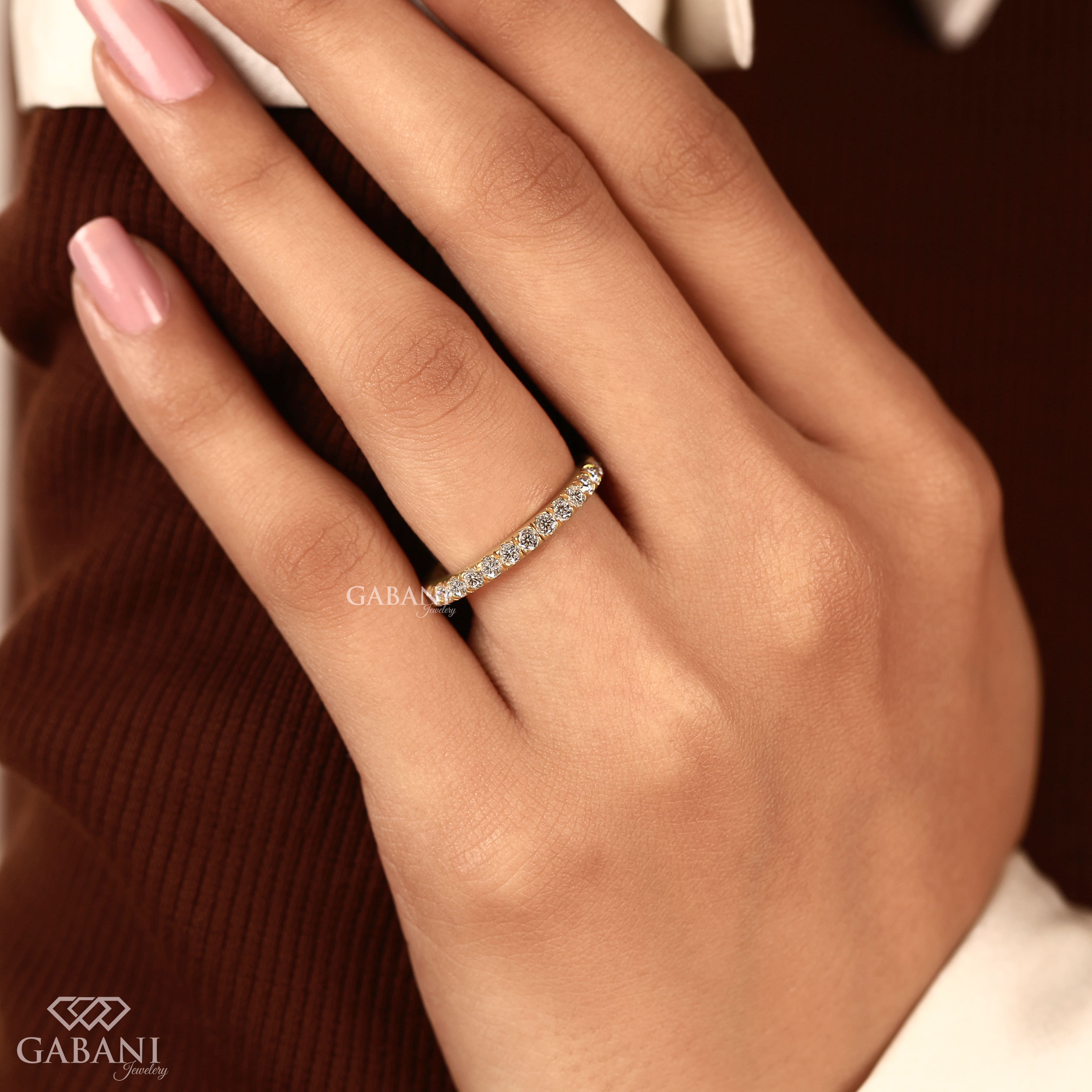 Round cut lab grown diamond eternity wedding band in yellow gold with continuous diamond setting and classic bridal style.