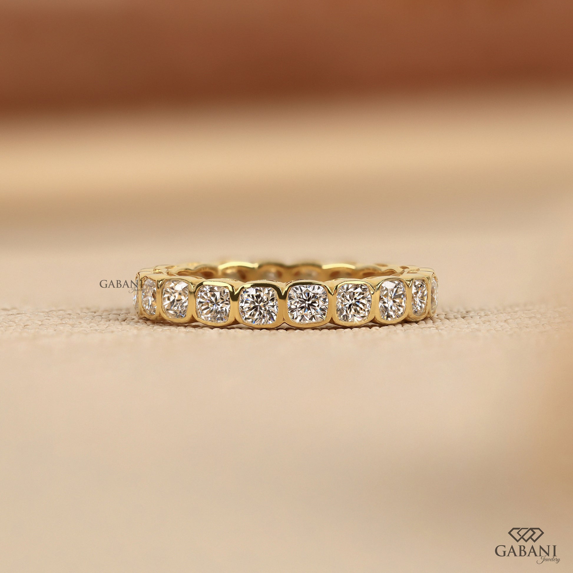 Bezel set cushion cut lab grown diamond eternity band with bold thick profile and polished metal finish