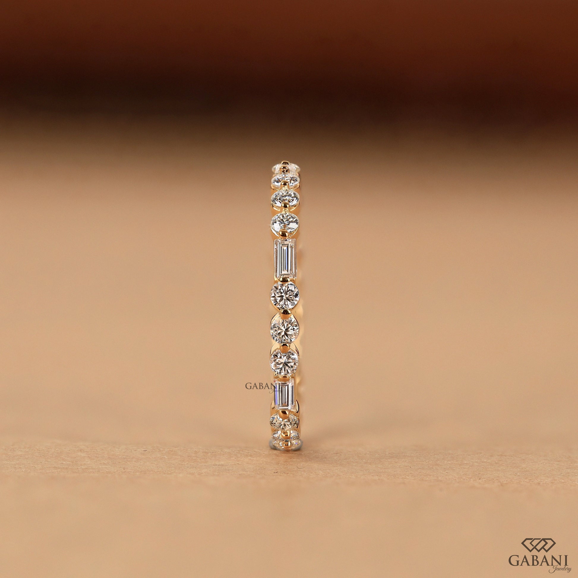 thin lab grown diamond wedding band with baguette and round stones in gold